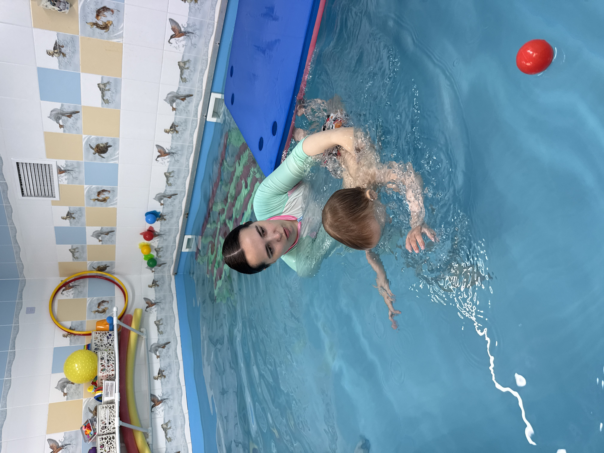 Woman teaches child to swim in Rusanovo pool