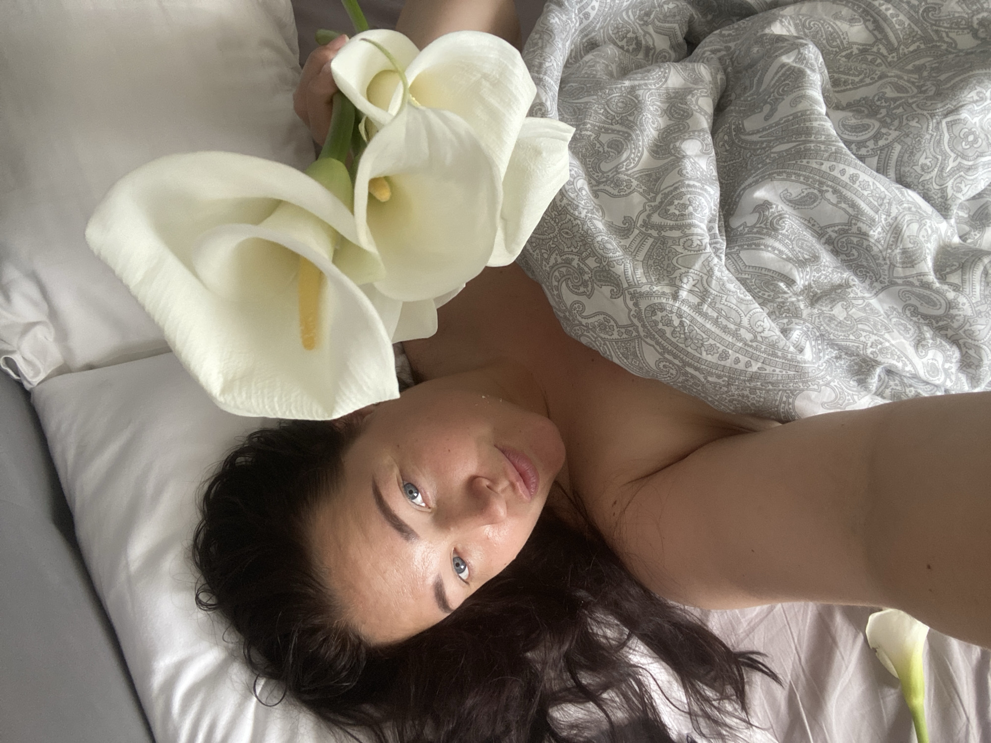 Woman photographs morning moments with flowers in Sochi bedroom