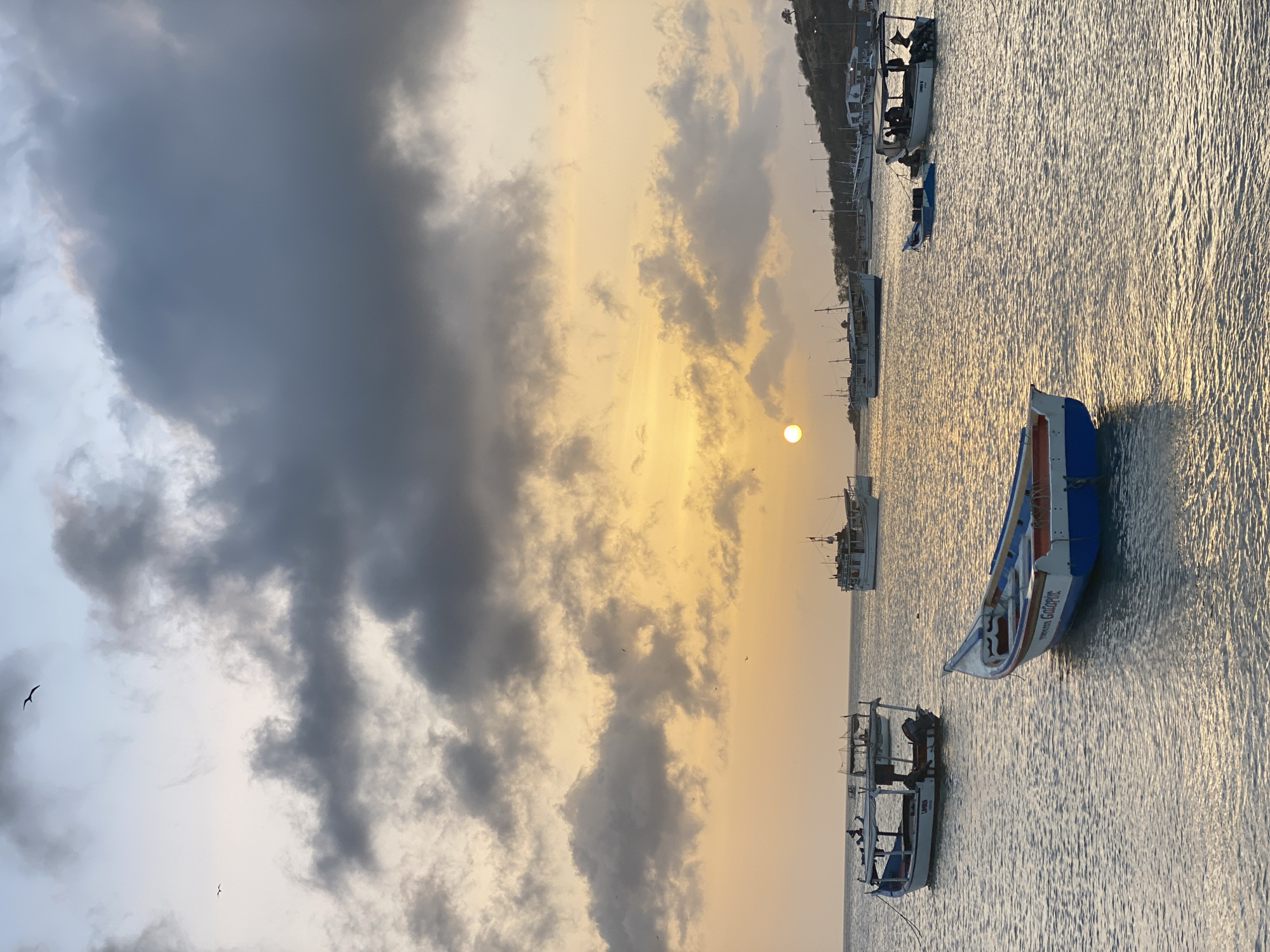 Sunset observed over Juan Griego waters with boats, storm clouds