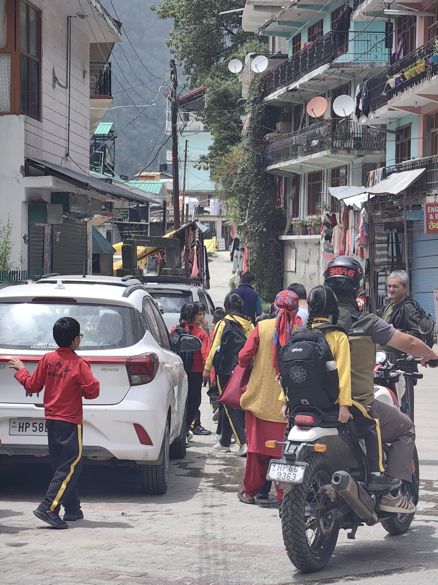Cloudy morning in Vashisht: school bus, stuck car, mountain town views