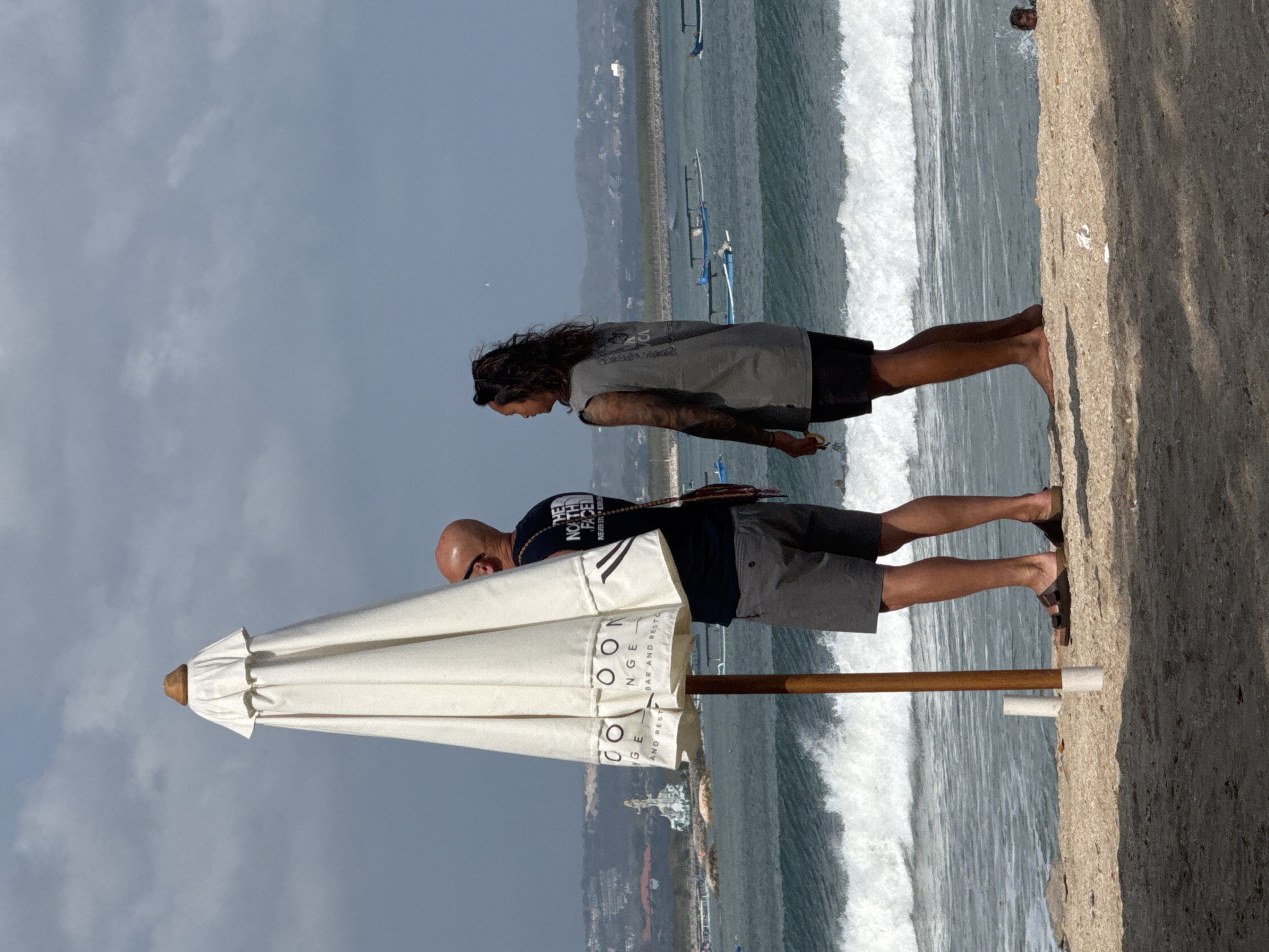 Kuta Beach in full swing: surfers, sunbathers, and shoreline activity