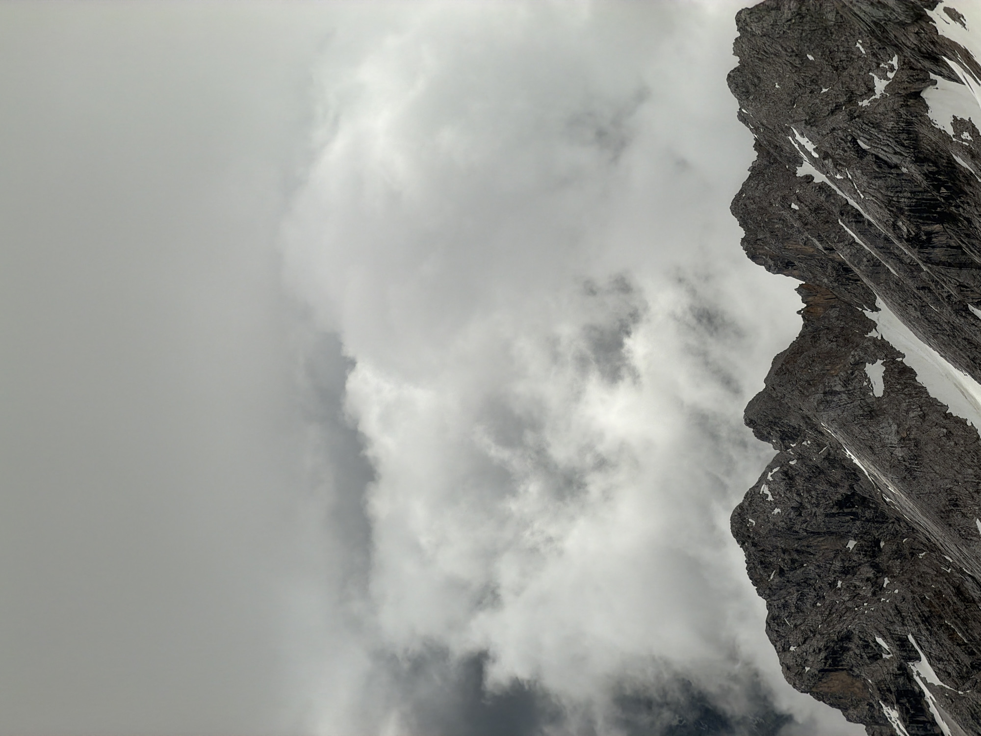 Cloudy mountain landscape with snow patches observed in Austria