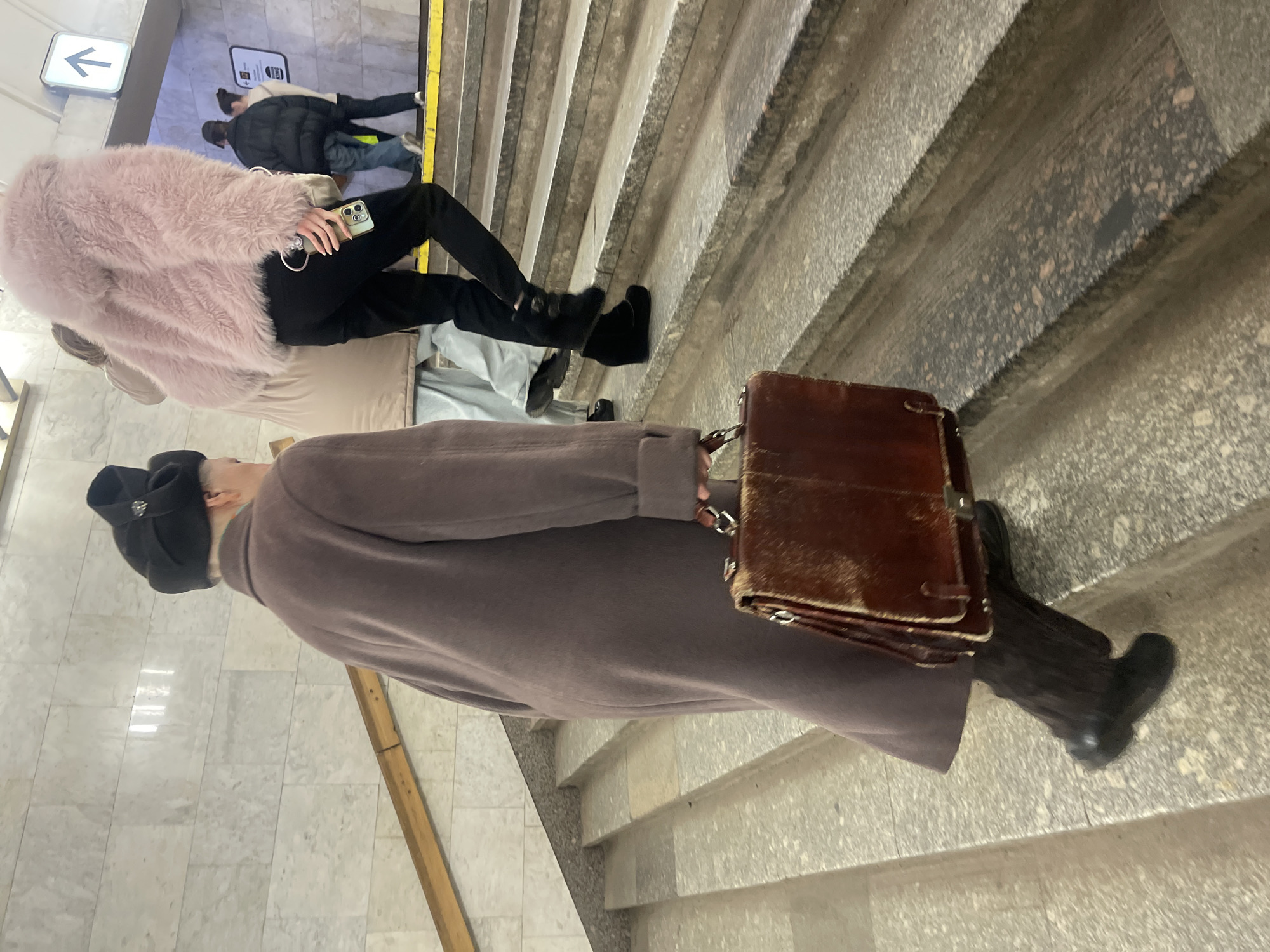 Person climbs stairs in busy Moscow metro station