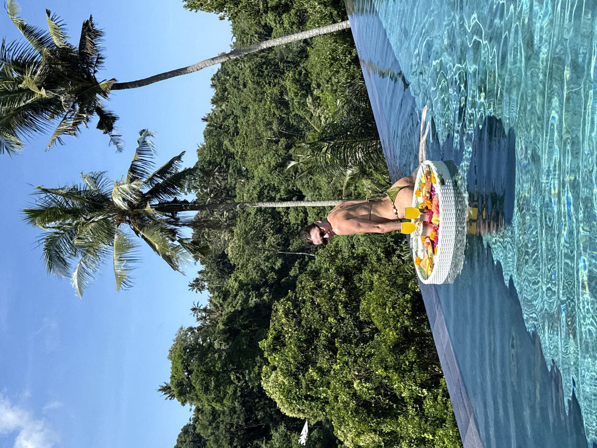 Woman enjoys floating breakfast at Ubud infinity pool