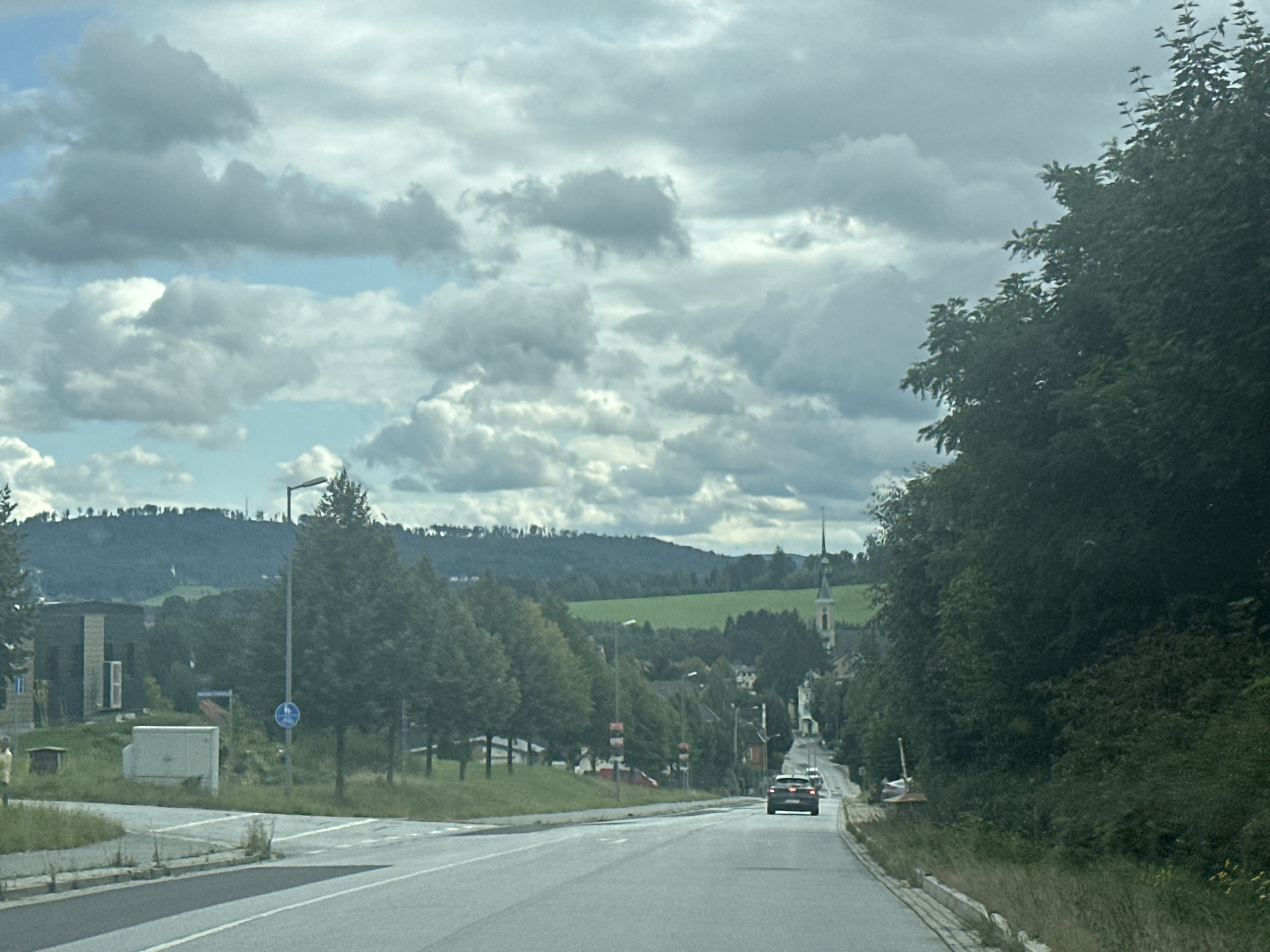 Quiet rural road curves through cloudy Großpostwitz countryside
