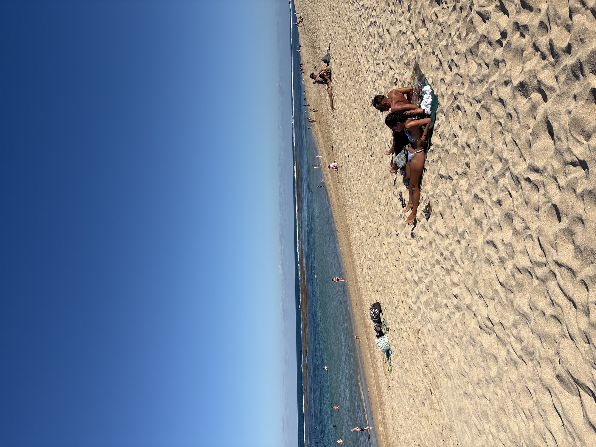 Morning beach activities unfold under clear skies in Kuta Selatan