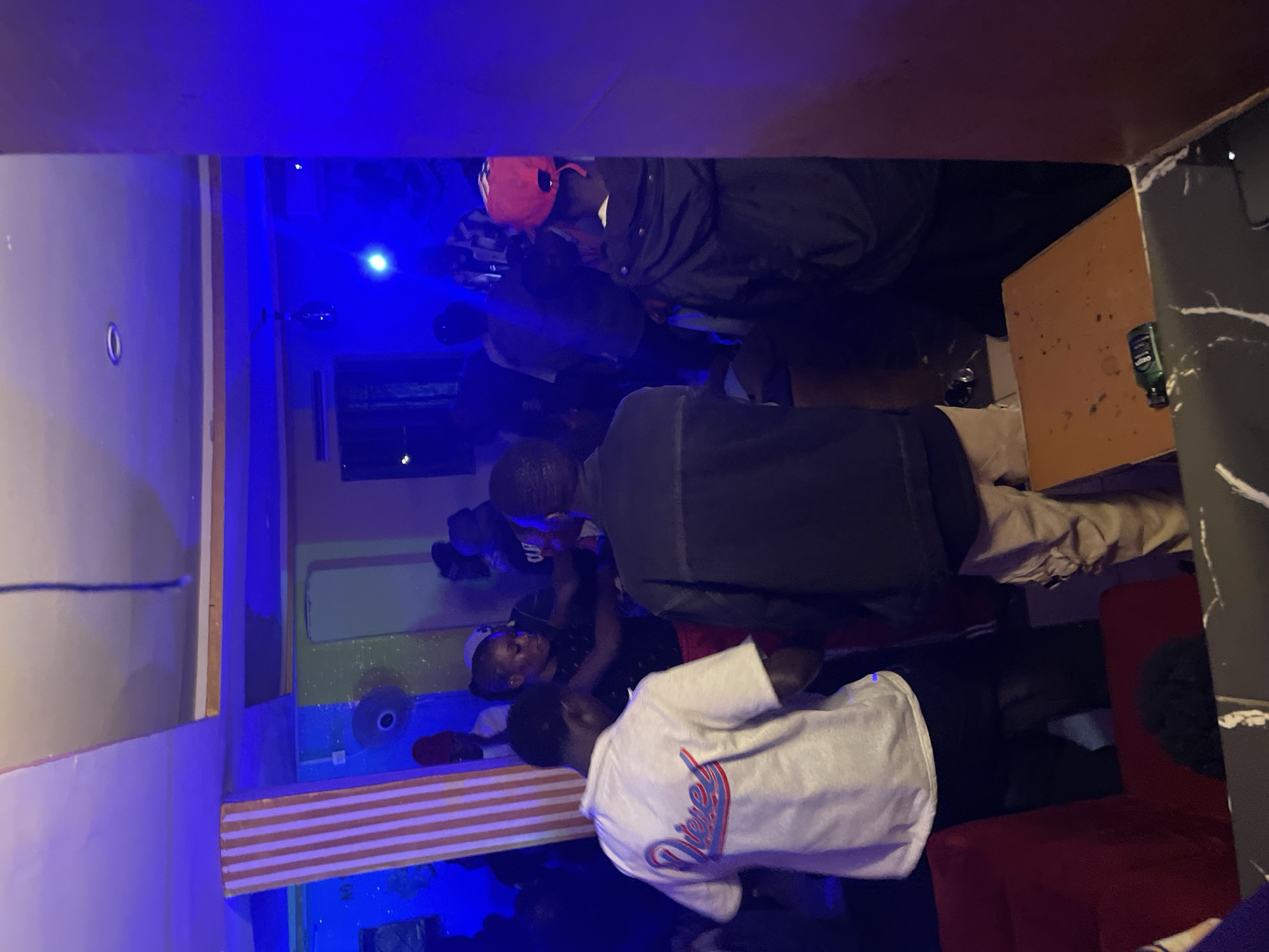 Late-night gathering at a Durumi lounge, blue lights and crowds