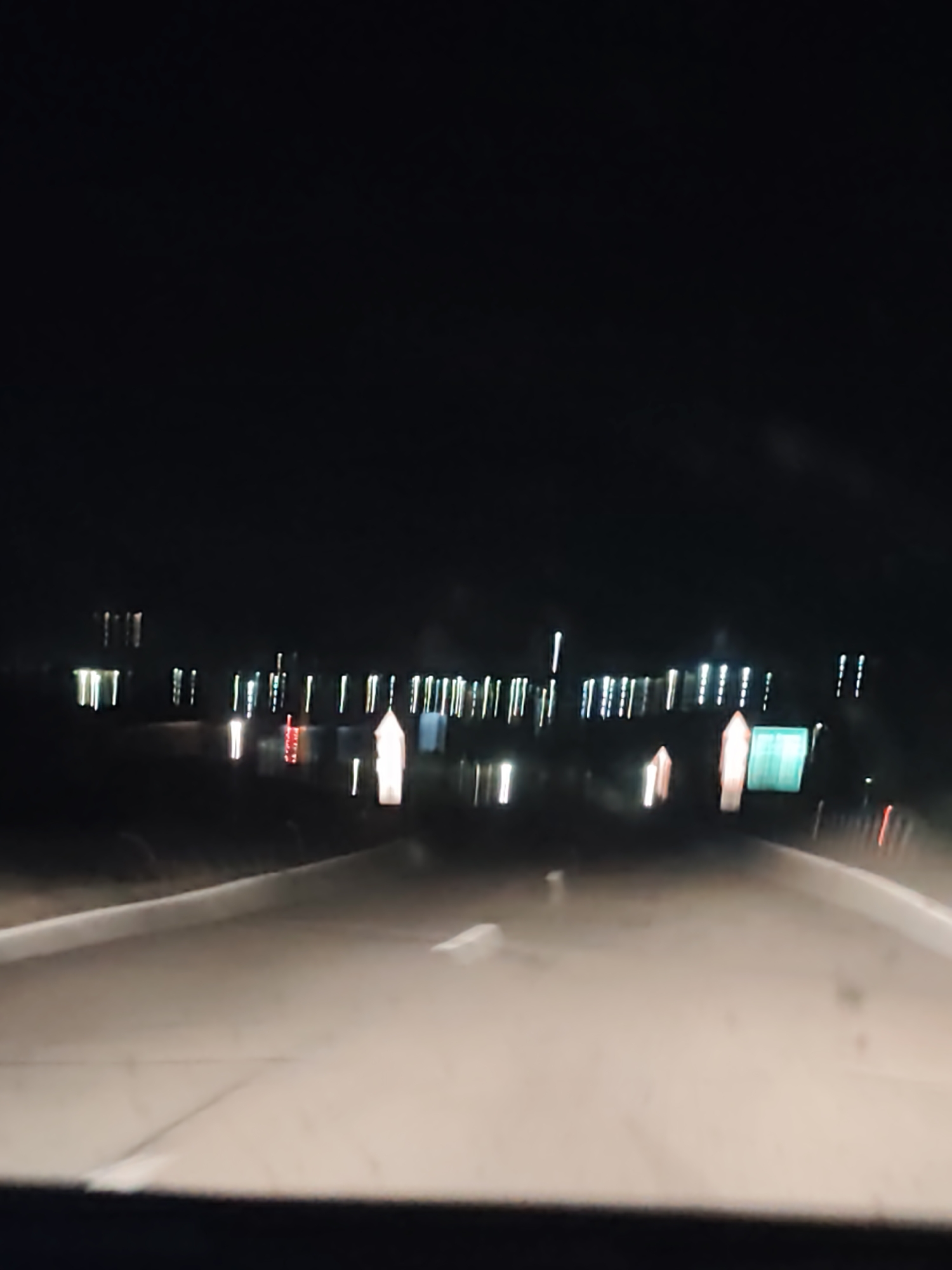 Nighttime vehicle travel captures distant lights near Bulgarian waterway
