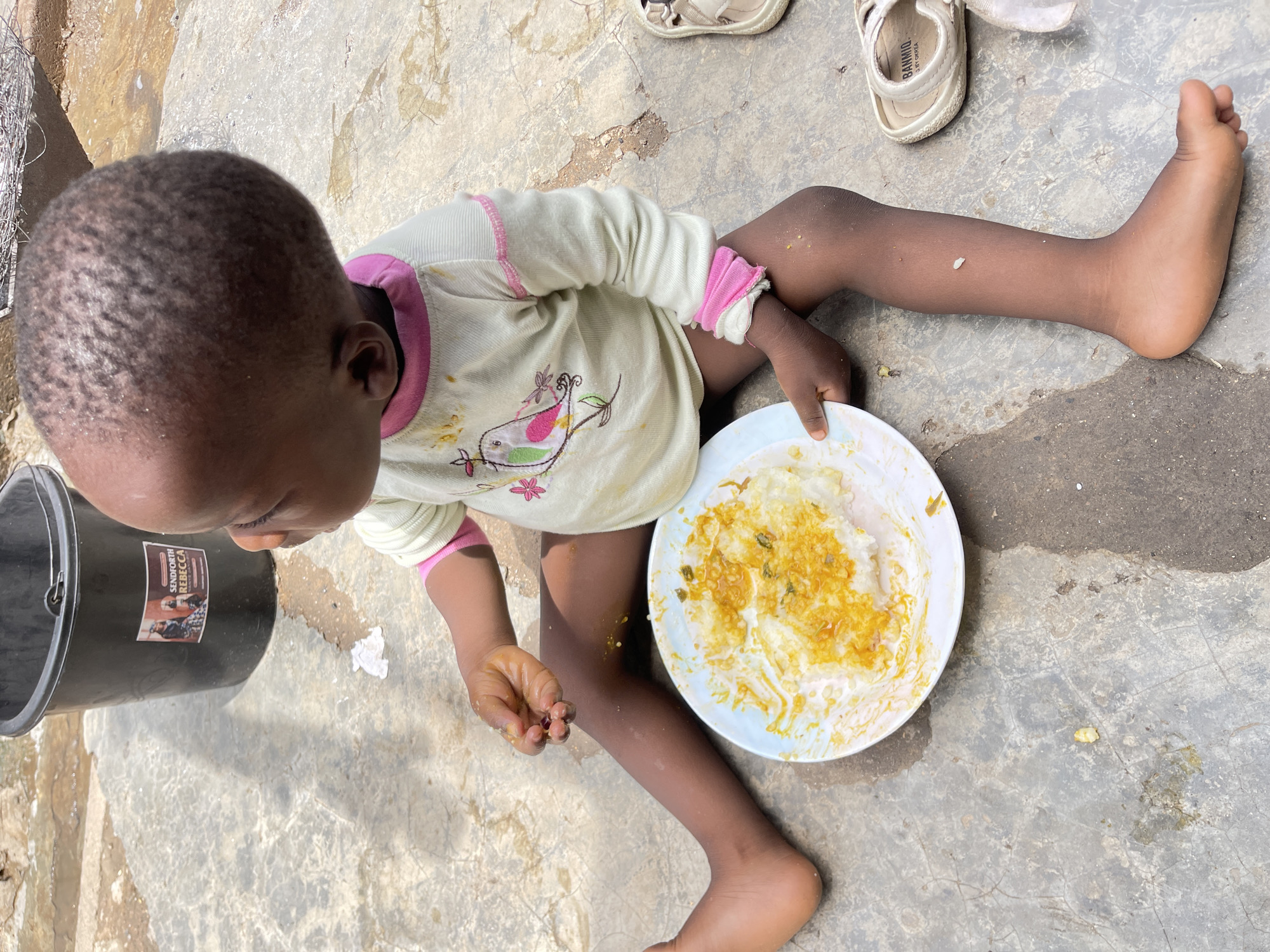 Child enjoys outdoor meal in Nyanya, Nigeria
