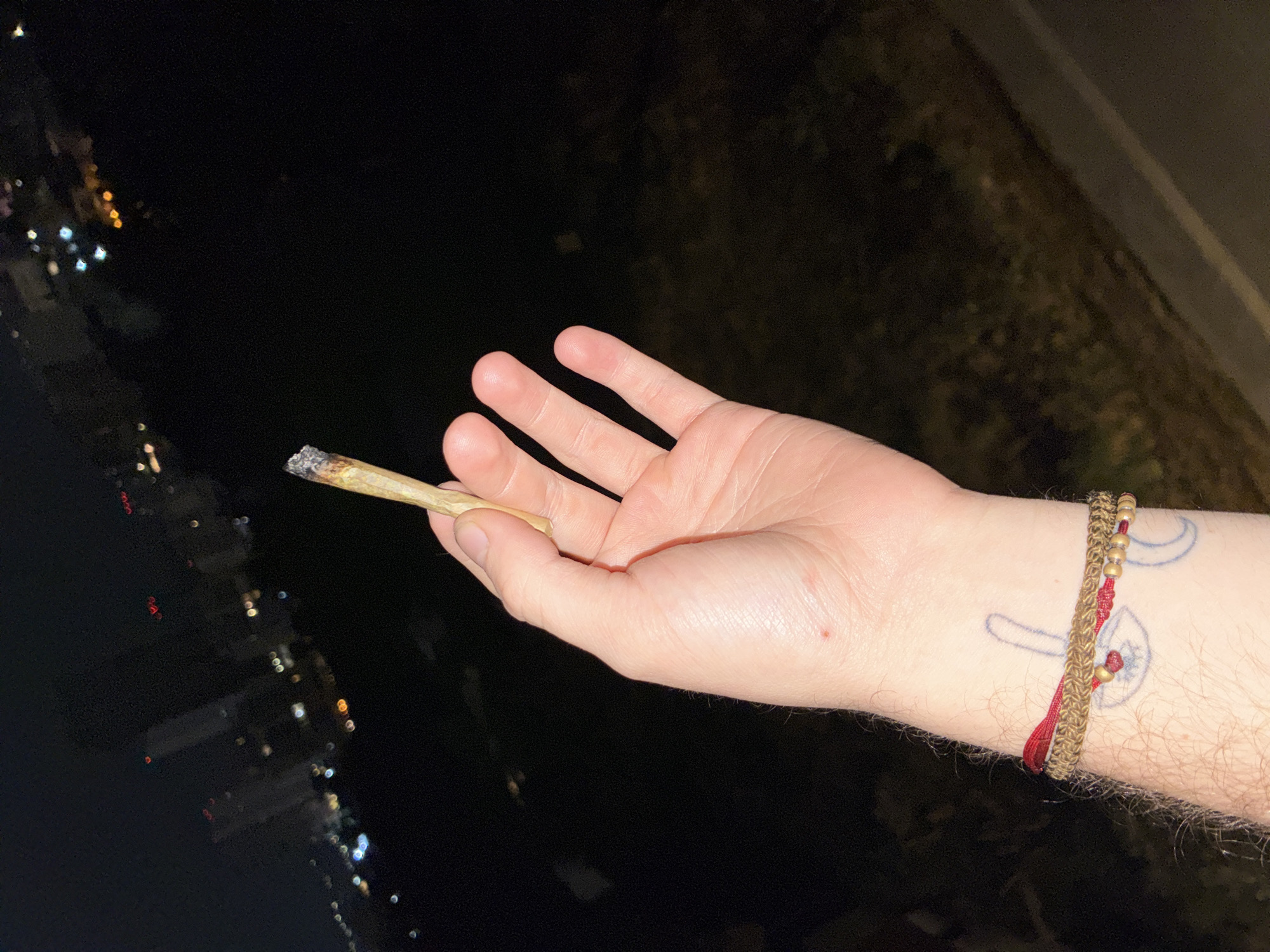 Person smokes marijuana overlooking foggy Huixquilucan skyline at night