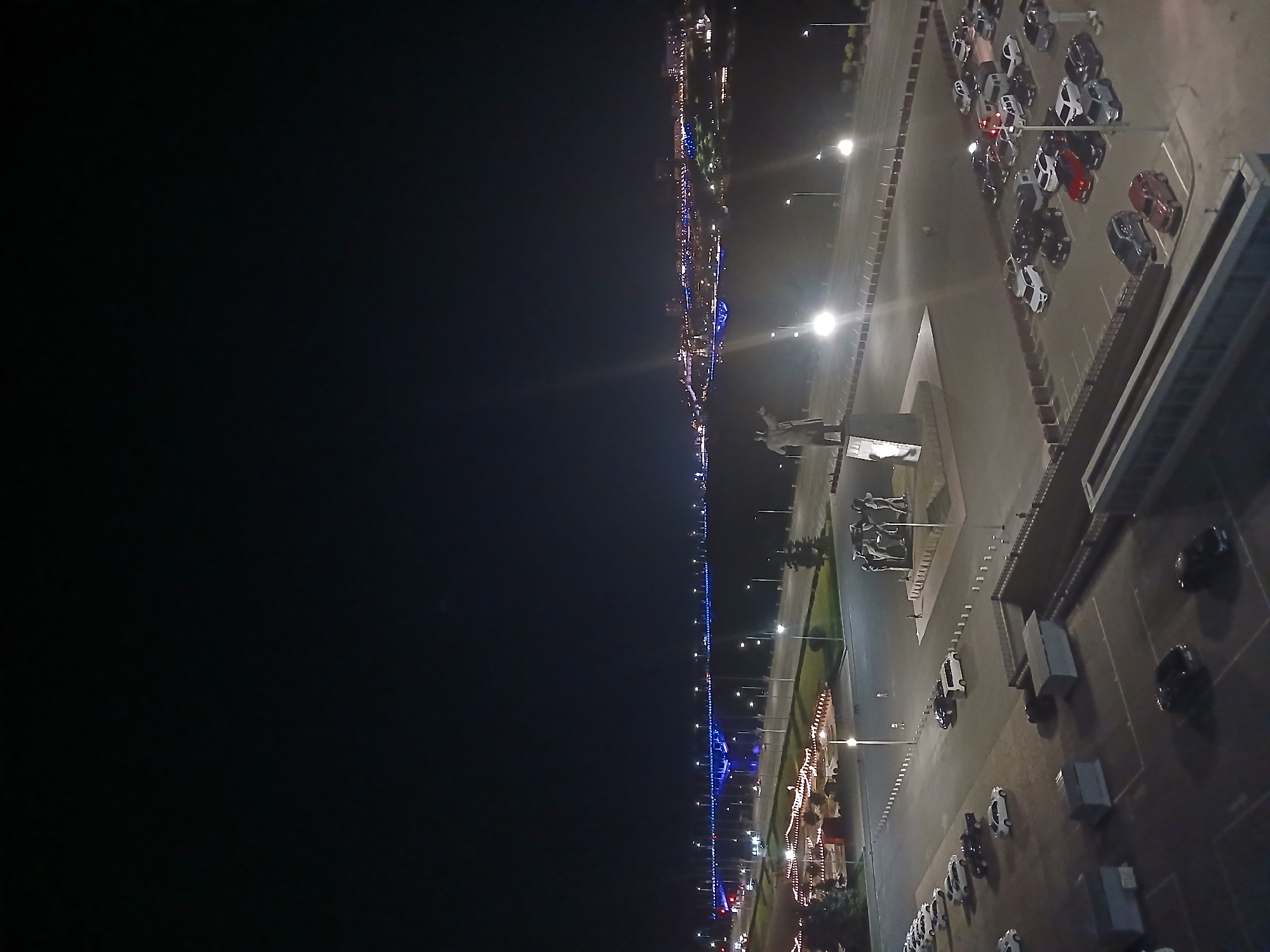 City waterfront at night, bridge lights reflecting on the water