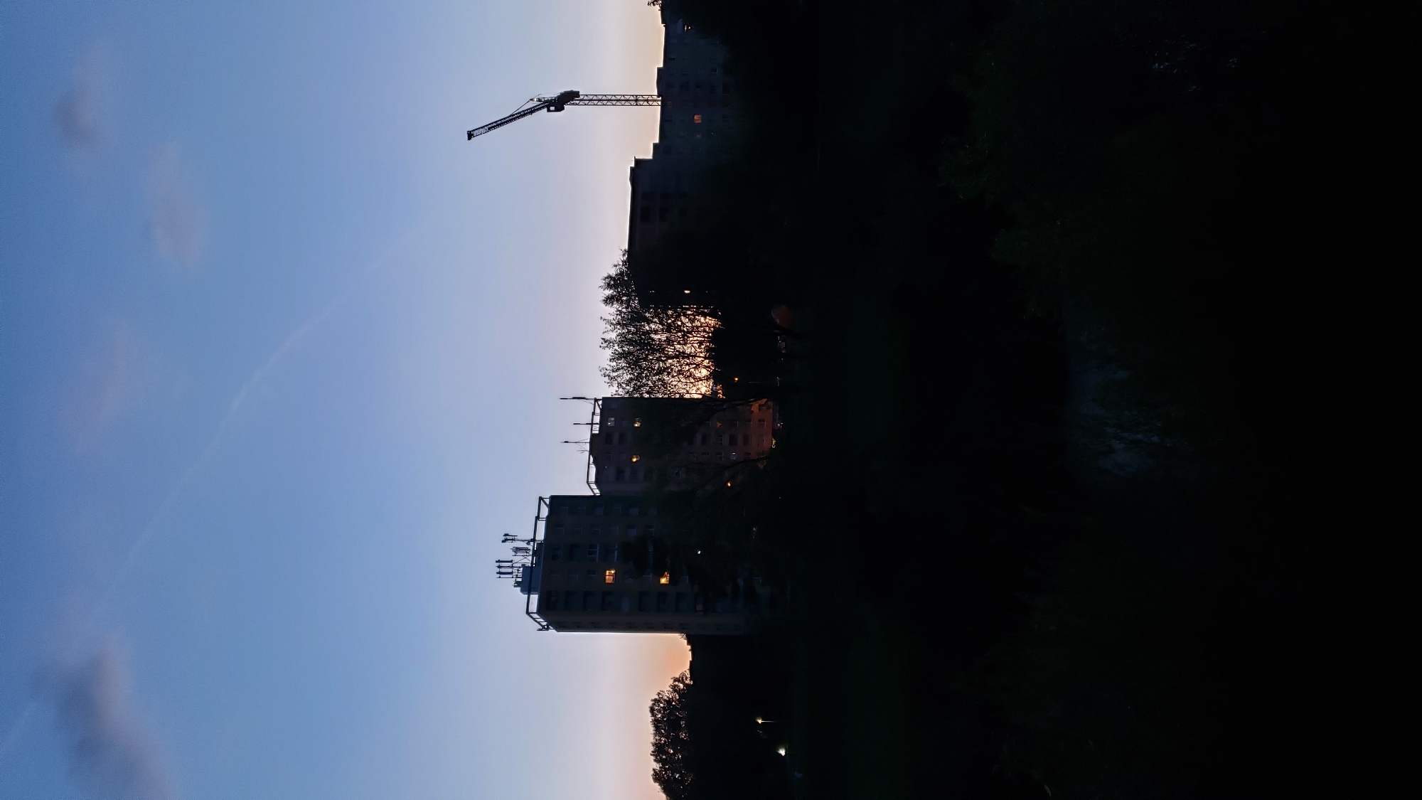 Prešov at dusk: river, bridges, and apartment blocks under a rising moon