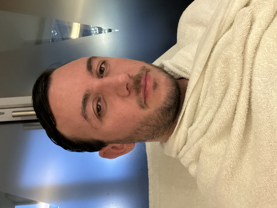 Man in towel spotted in London indoor setting