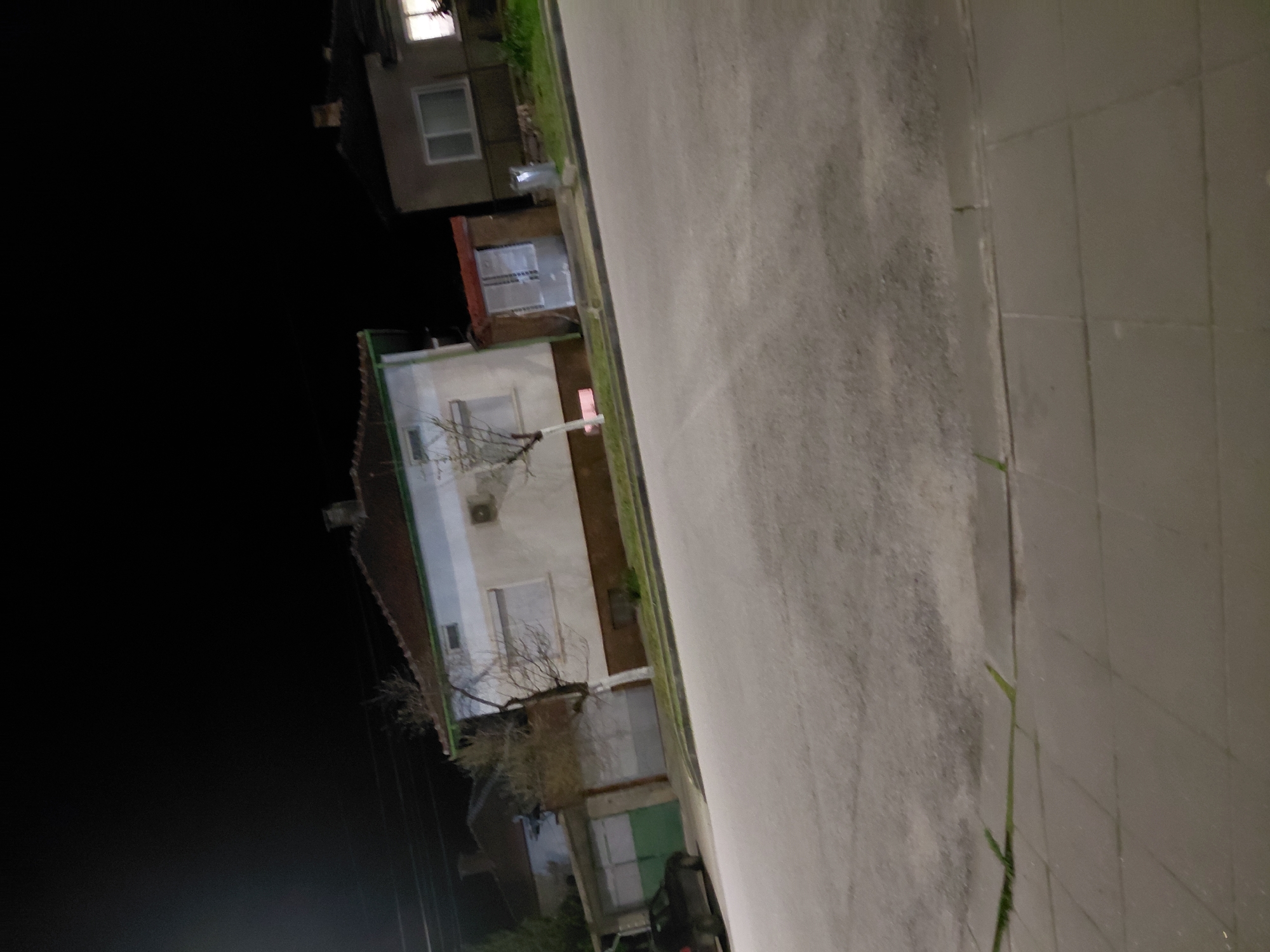 Nighttime urban street scene with lit residential buildings observed