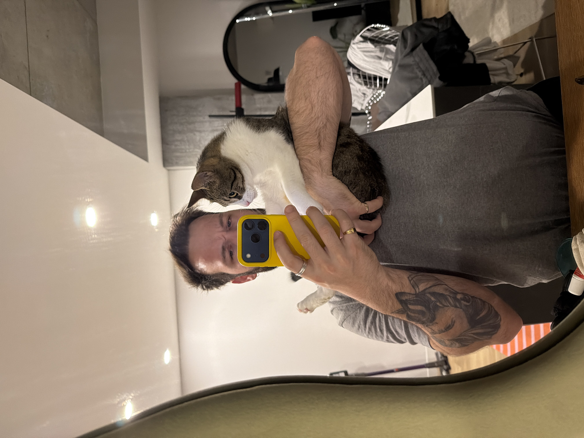 Man takes mirror selfie with cat companion in Laval