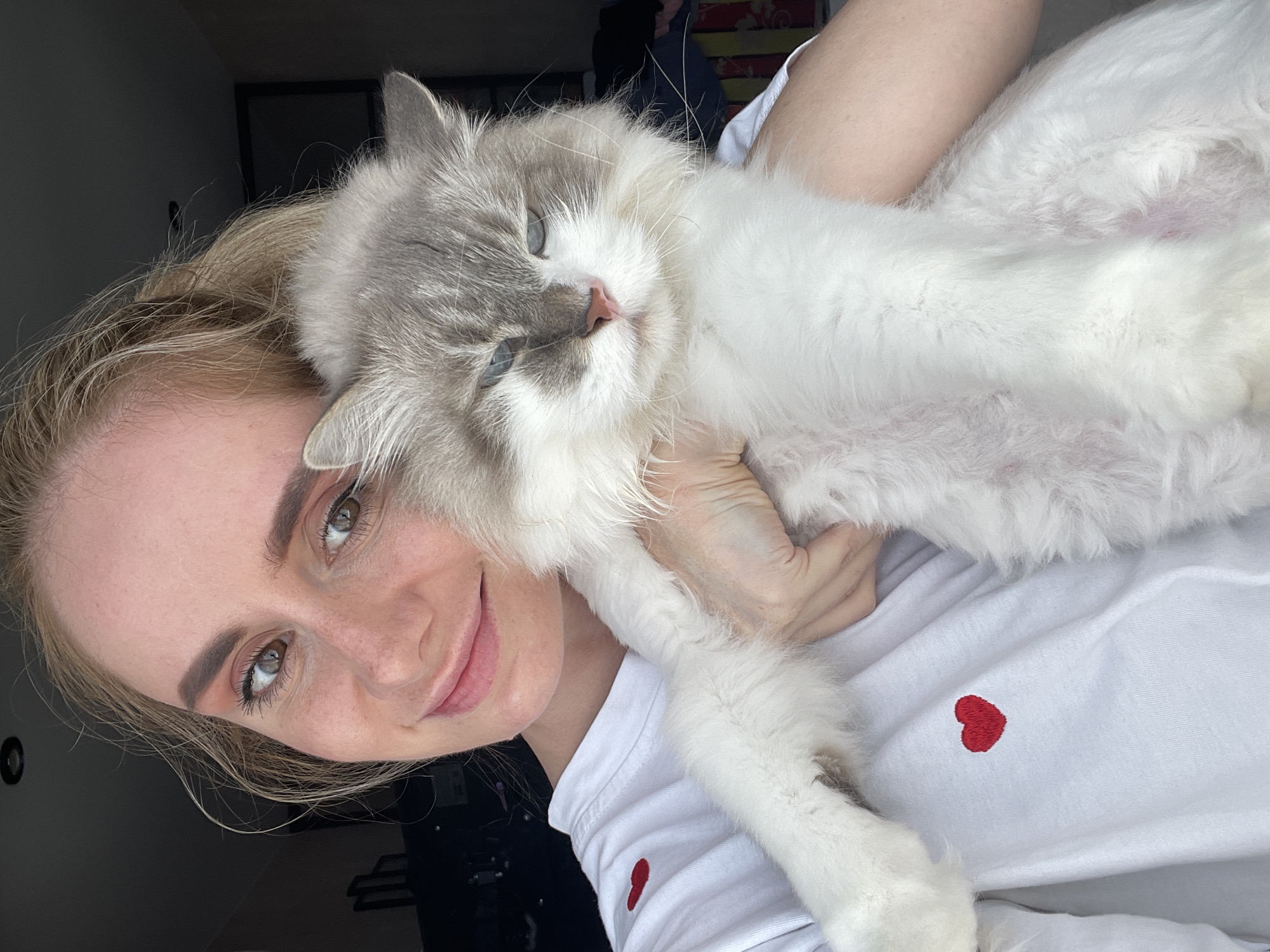 Woman poses with fluffy cat in early morning Vladivostok