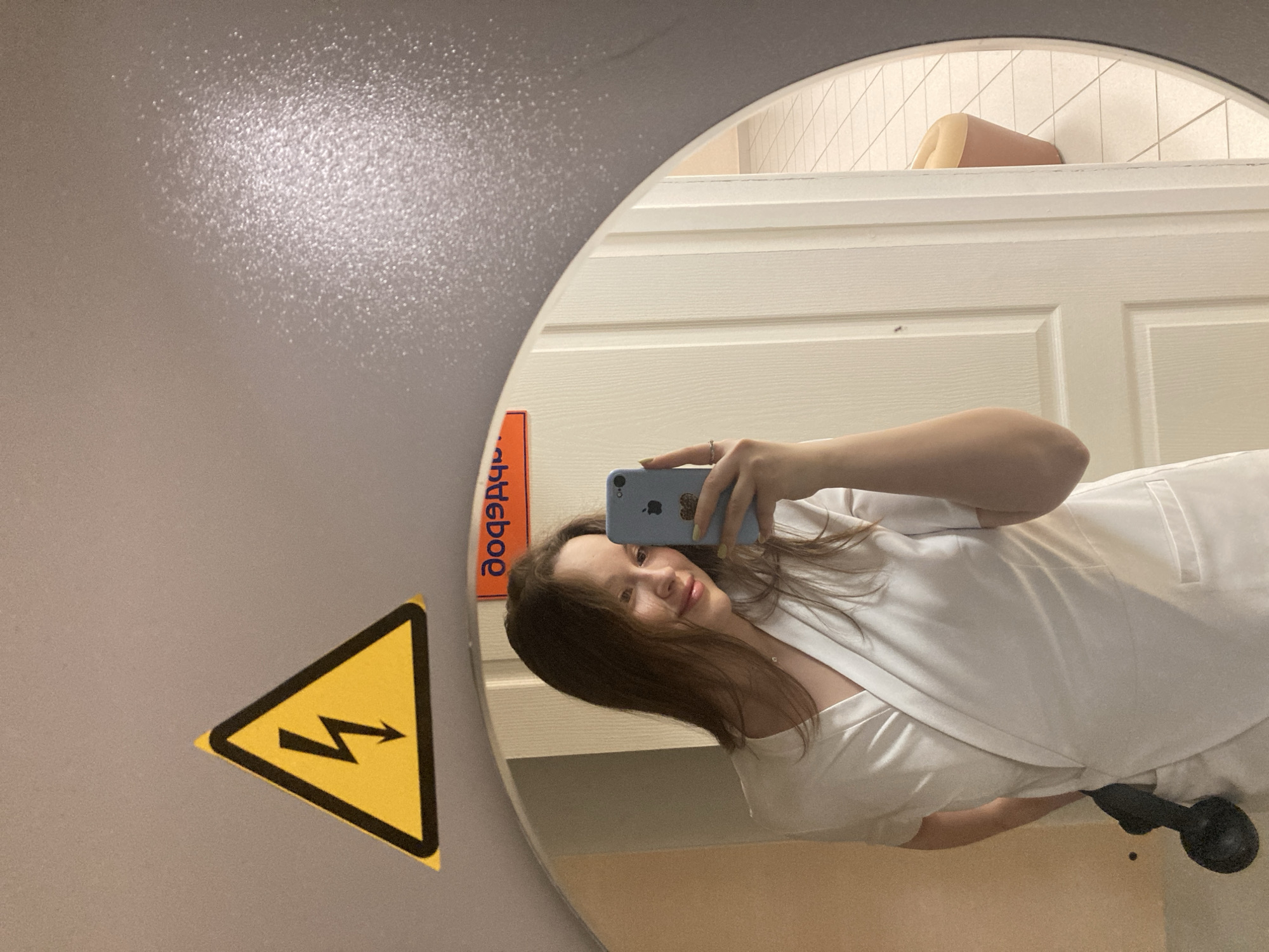 Woman takes mirror selfie in Chaikovsky public restroom