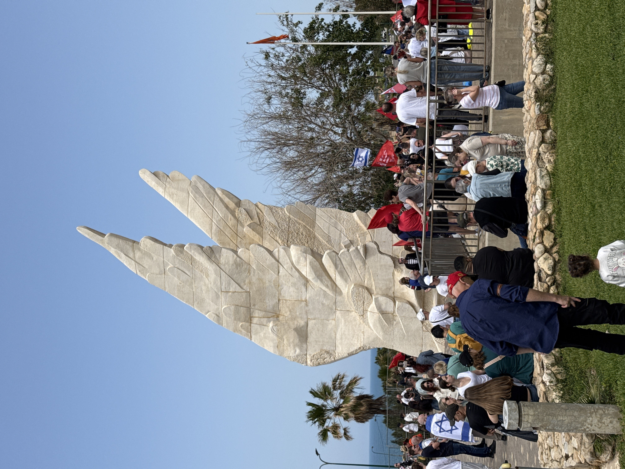 Memorial gathering with flags and portraits in Netanya