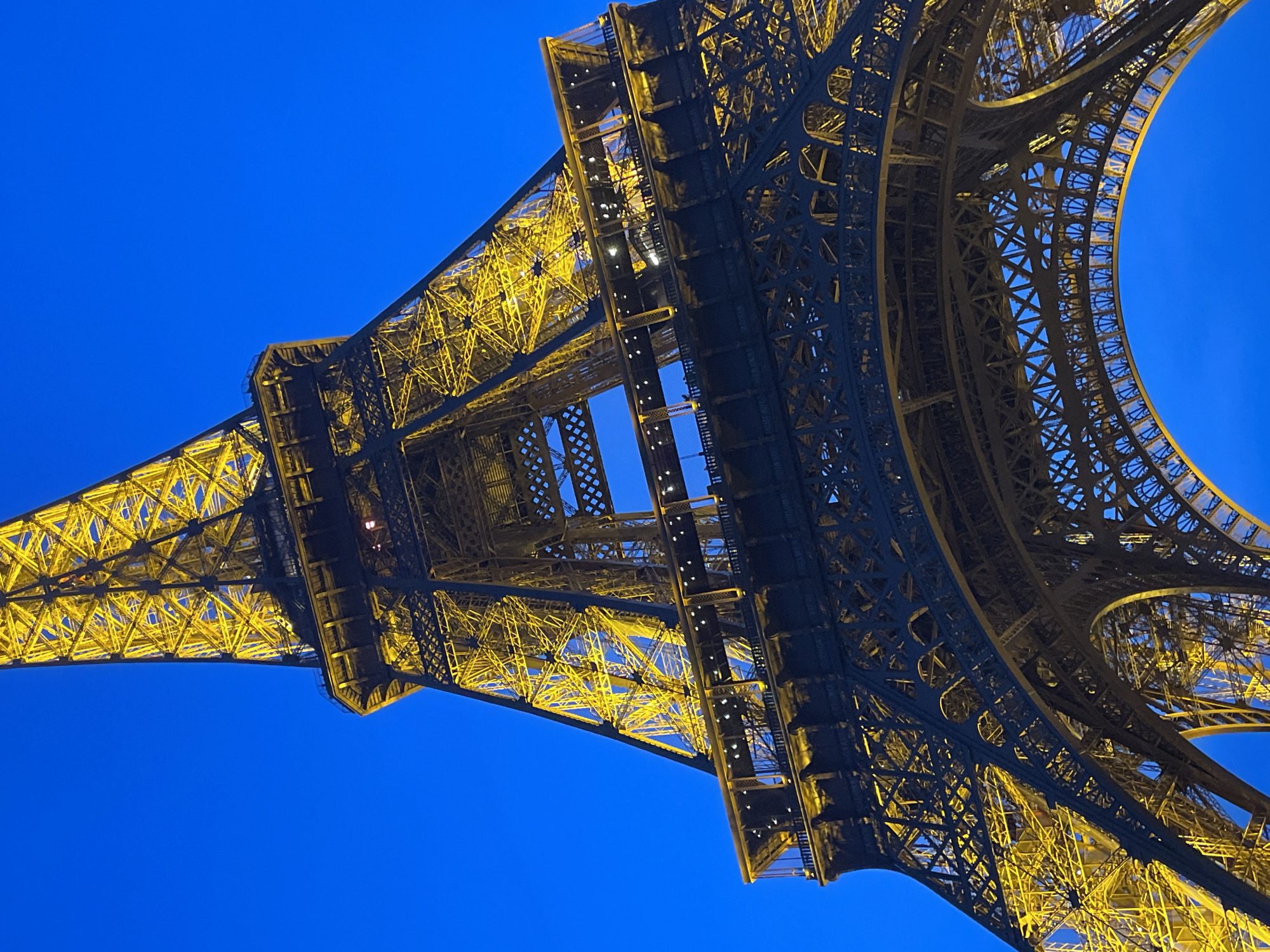 Evening crowds gather at Champ de Mars for illuminated Eiffel Tower views
