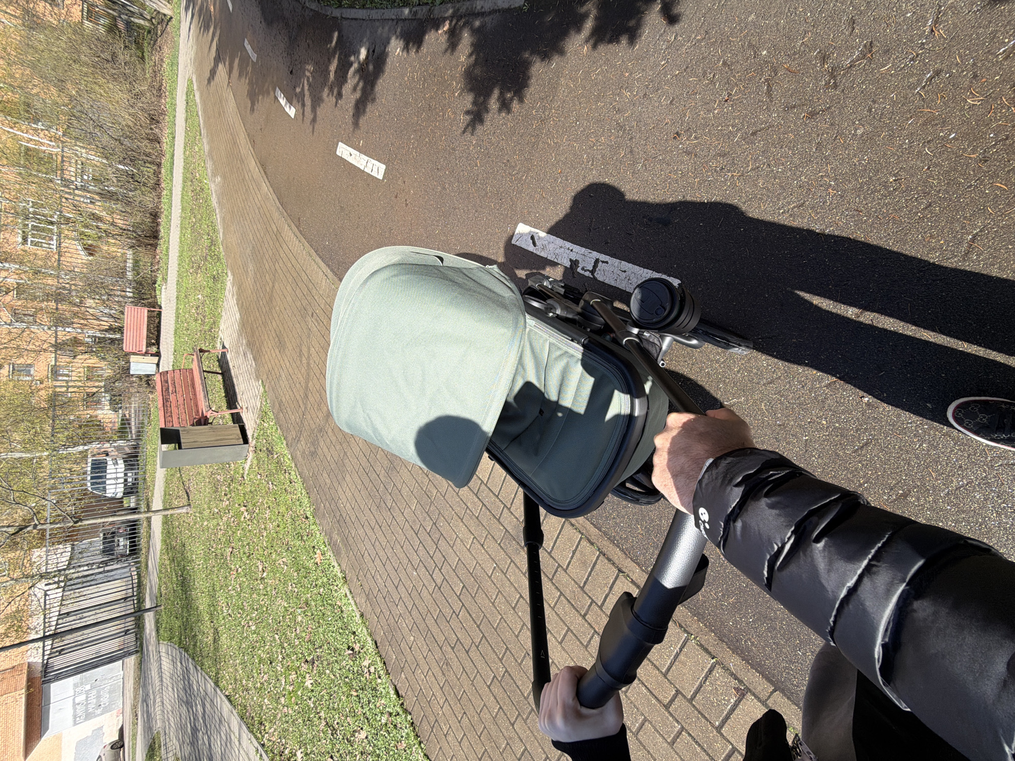 Person pushes baby stroller on sunny day in Moscow