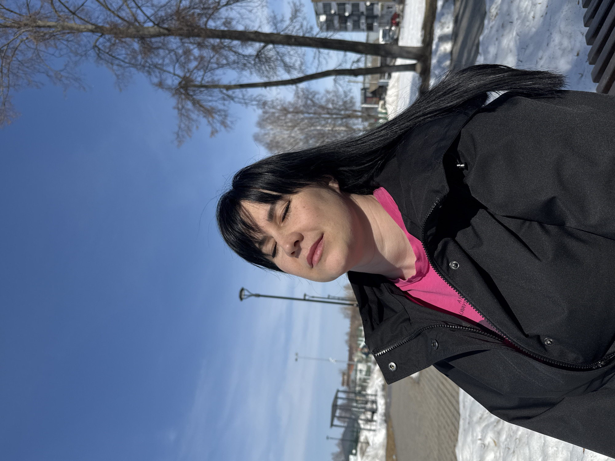 Woman takes selfies while drinking coffee in snowy Russian park