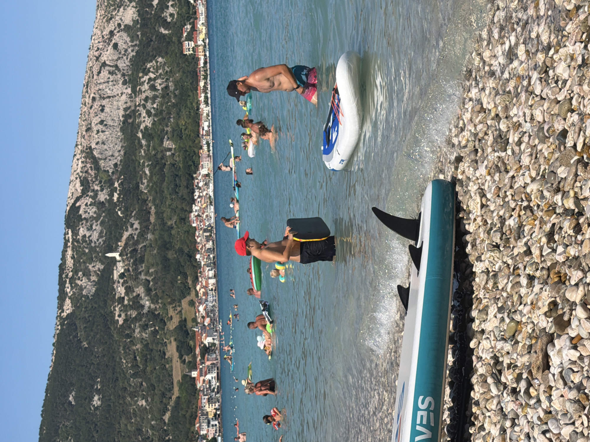 Crowded summer afternoon at Baška's pebble beach, Croatia