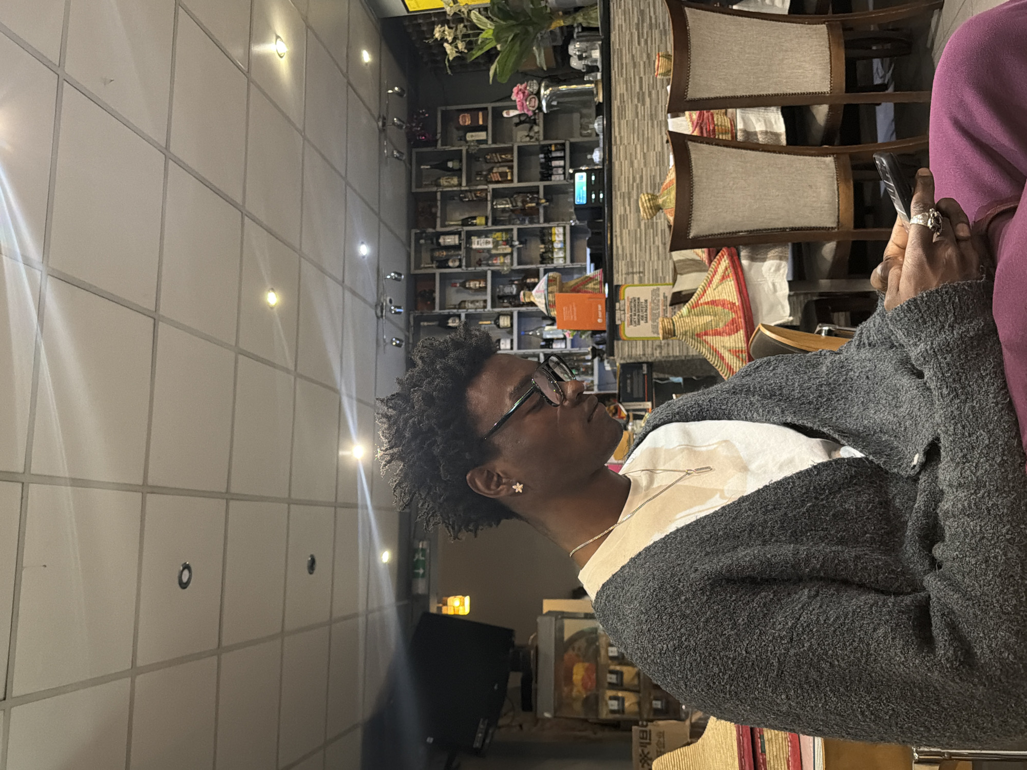 Person with flower earring photographed indoors in London