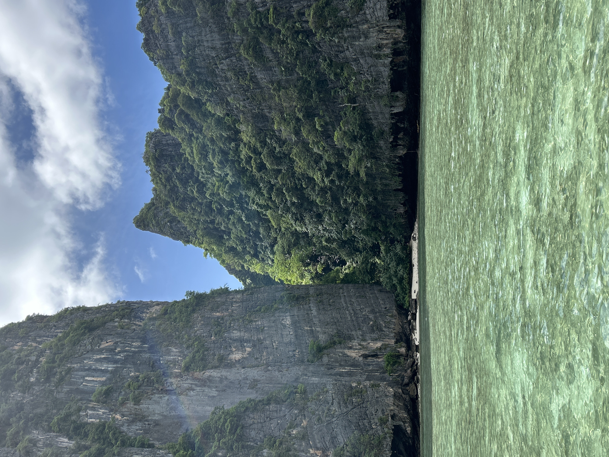 Boat cuts through a limestone-flanked sea passage near Ao Nang