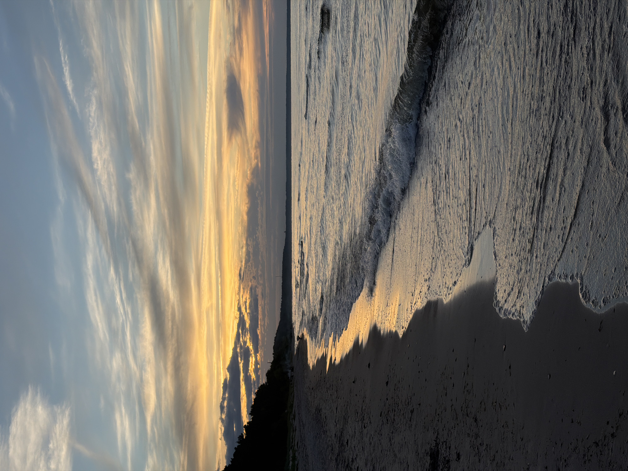 Dusk settles over a dark sand beach in coastal Latvia