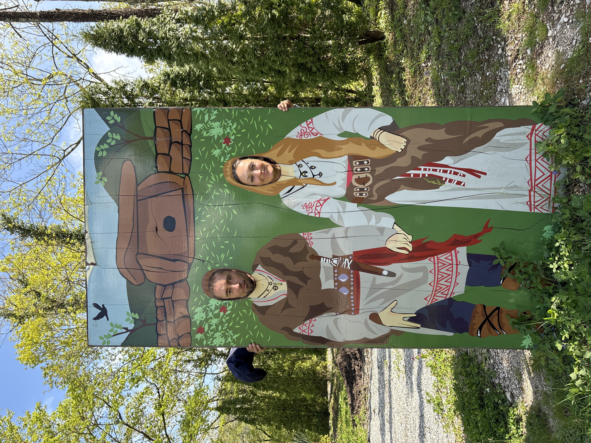 Tourists pose with folk costume cutout in Pshada