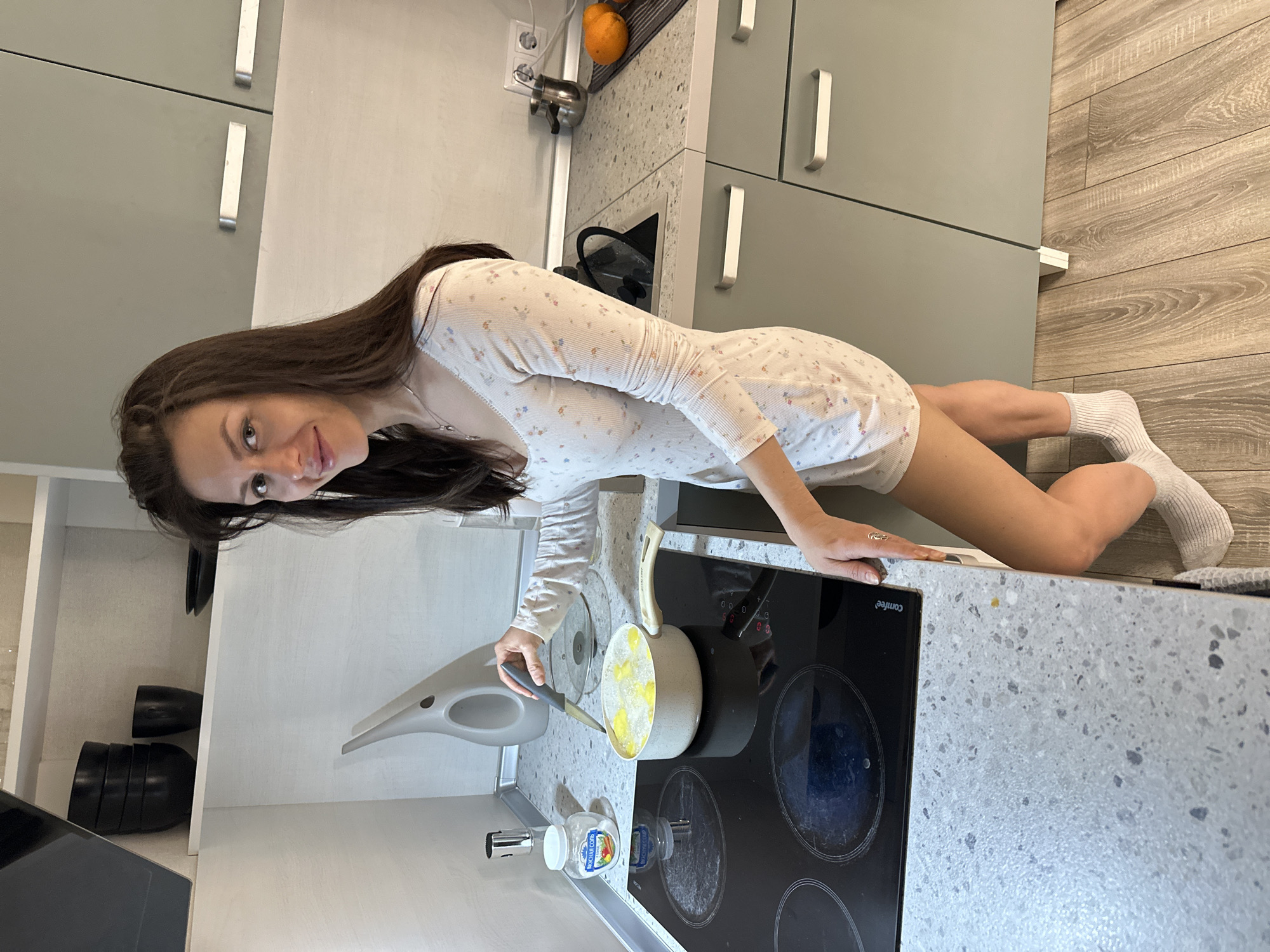 Woman cooks potatoes in Murino apartment kitchen