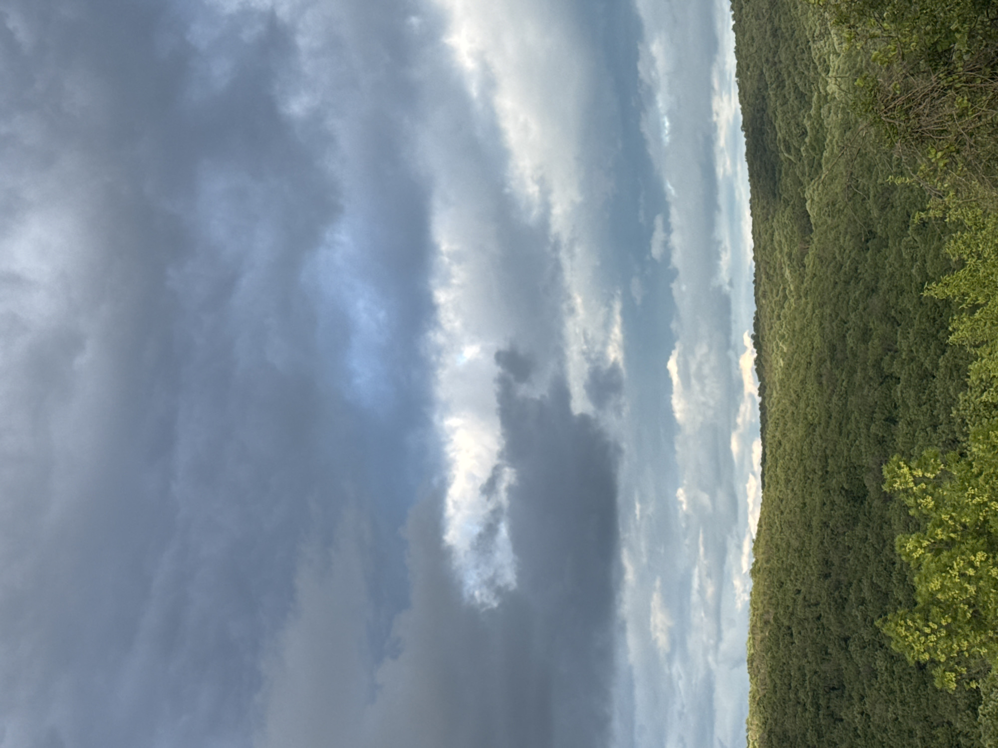 Full rainbow appears over Bulgarian countryside during cloudy afternoon