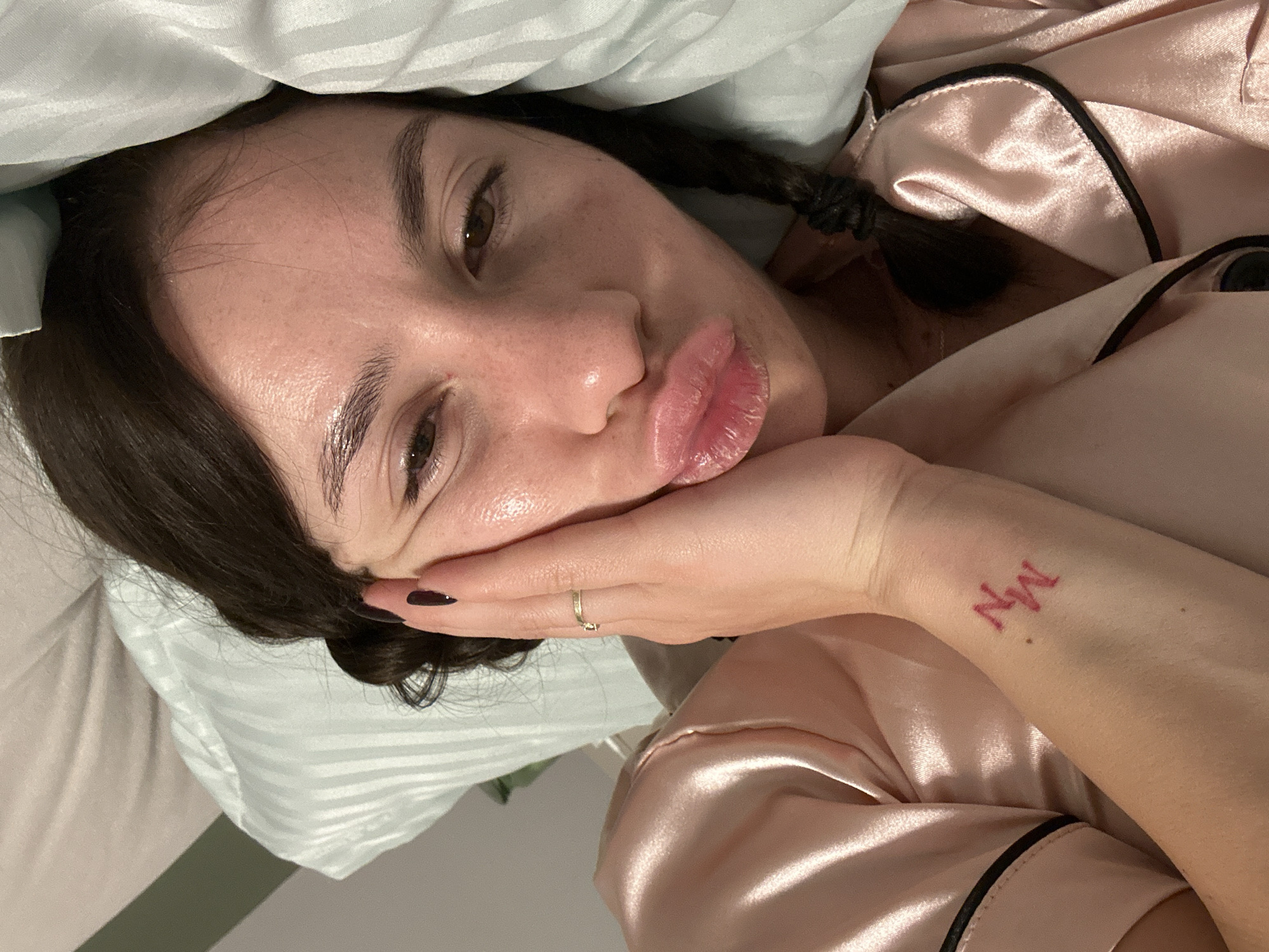 Woman in pink pajamas rests in bed in Plovdiv
