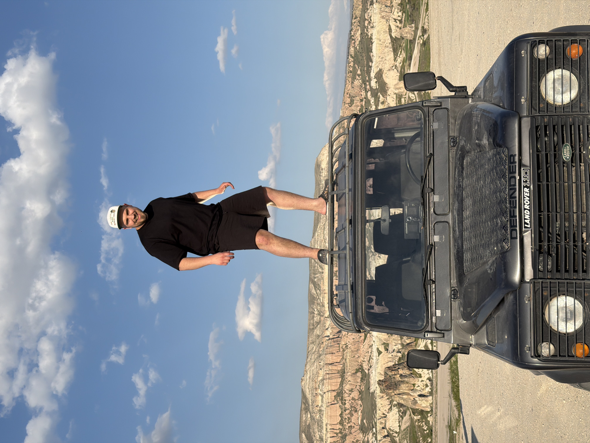 Man poses on Land Rover in Göreme's geological landscape