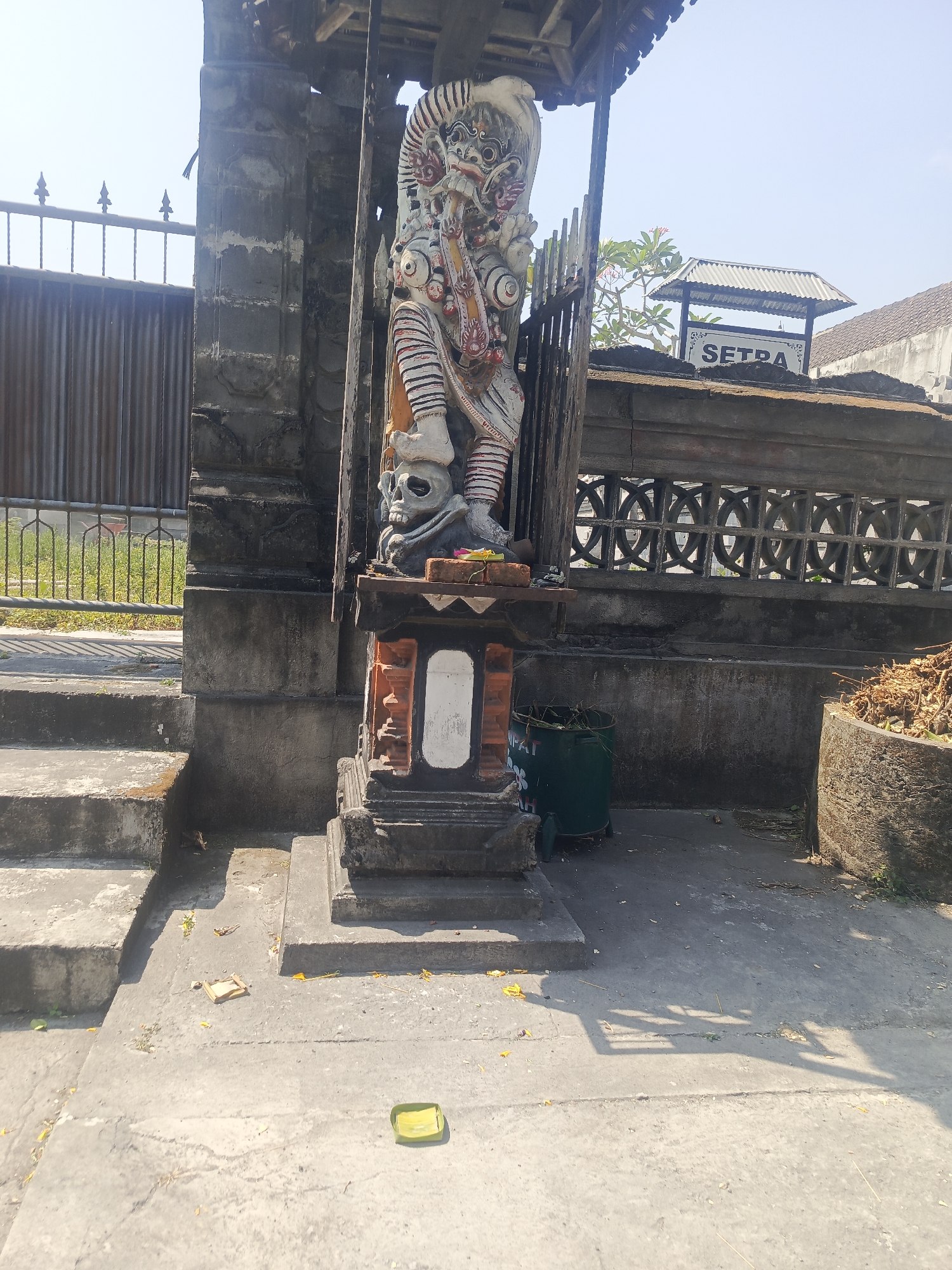Temple statues, frangipani, and stonework in Mengwi, Bali