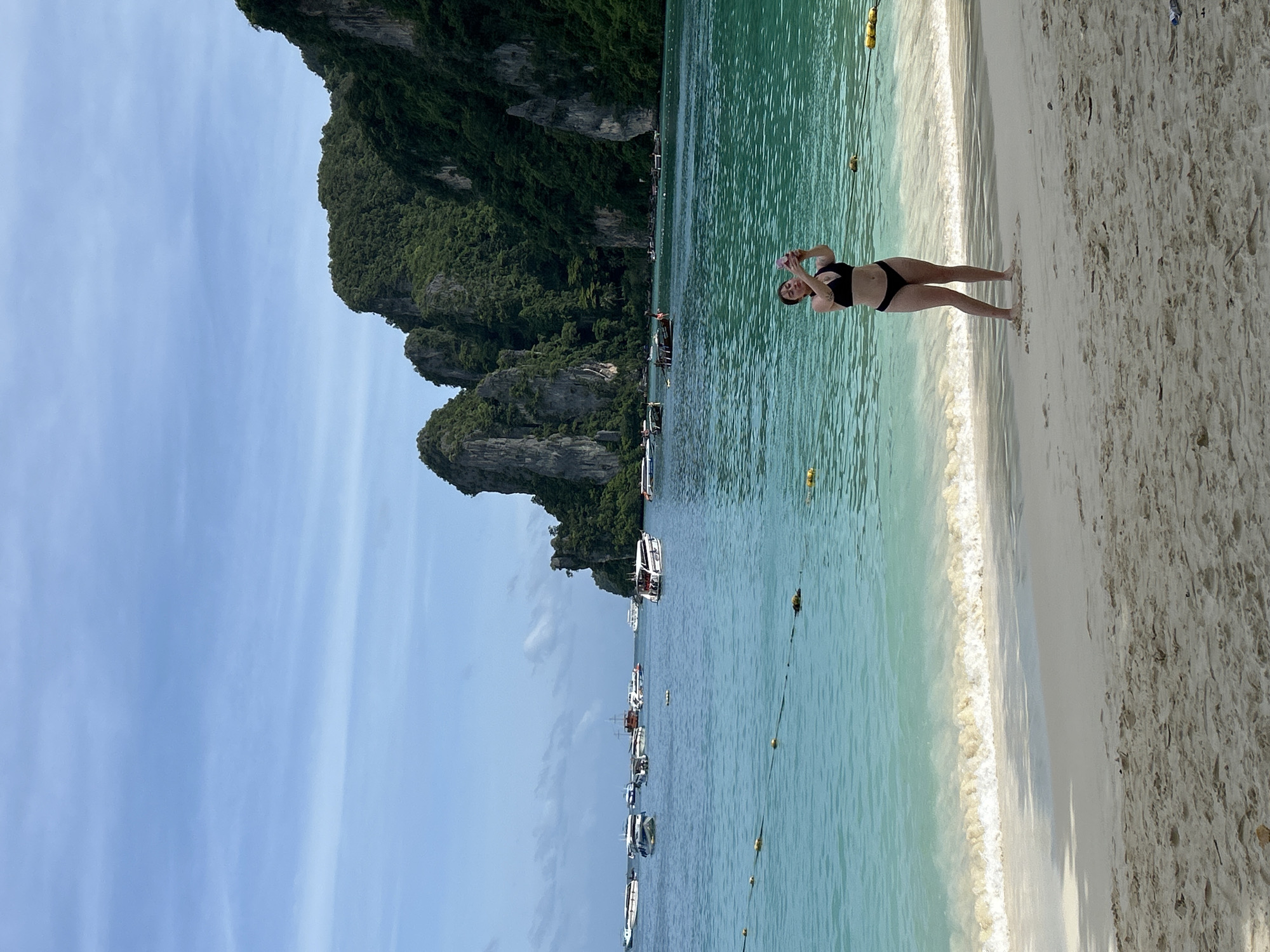 Morning beach scene at Ao Nang with tourists and ferry activity