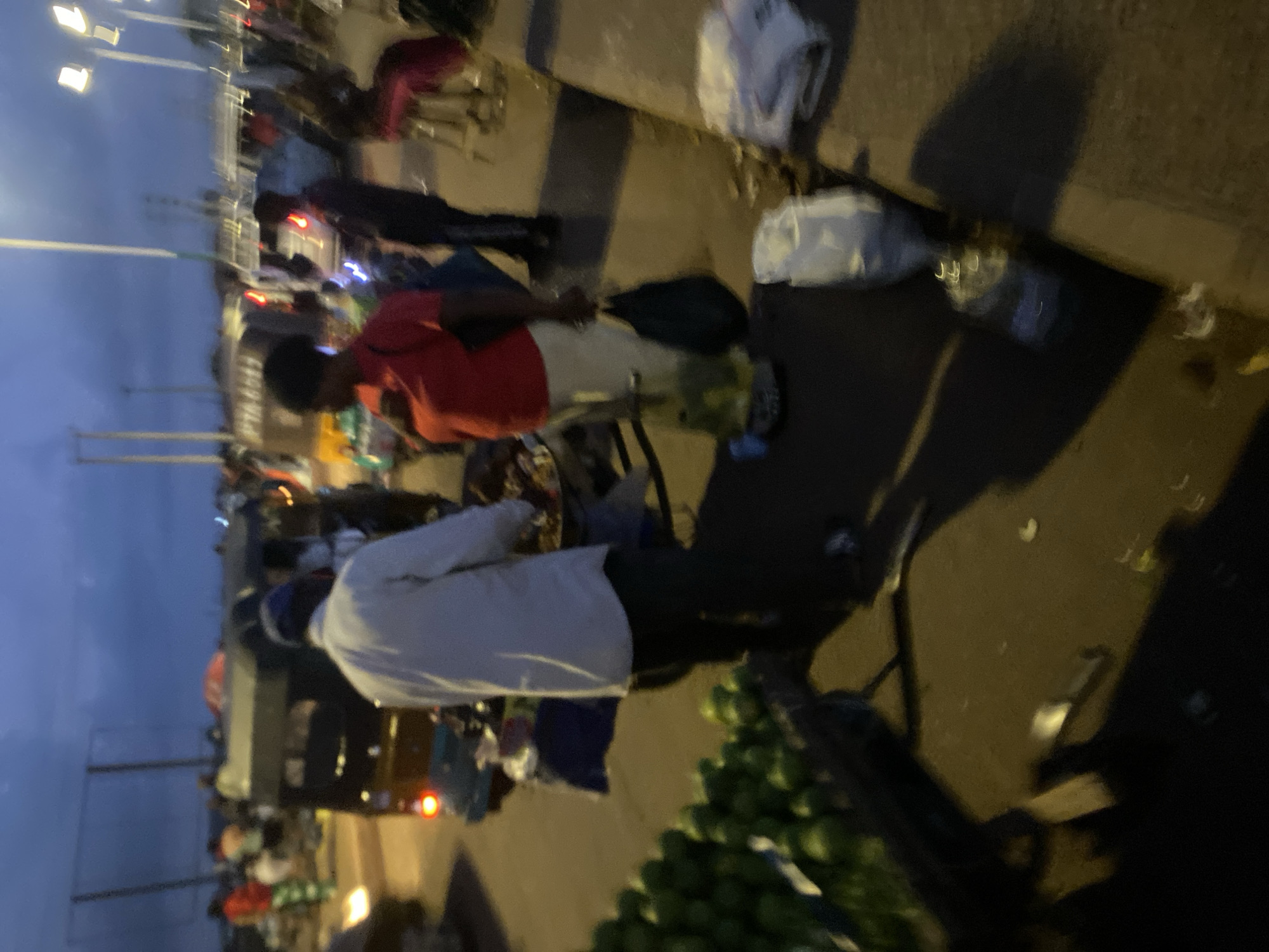 Evening street market bustles under streetlights in Bukuru Nigeria