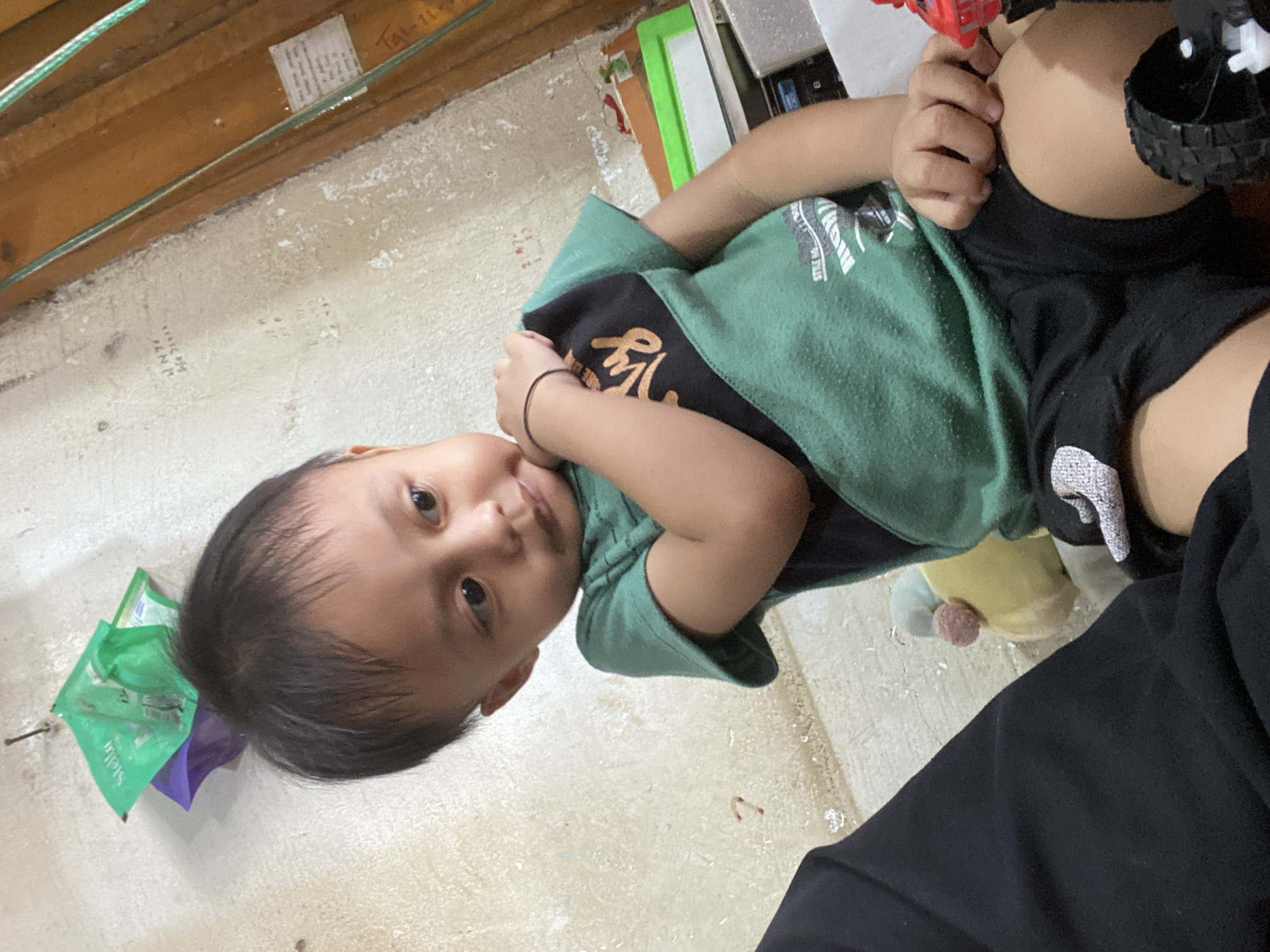 Kids hanging out indoors in Ta', Indonesia, tablet in hand