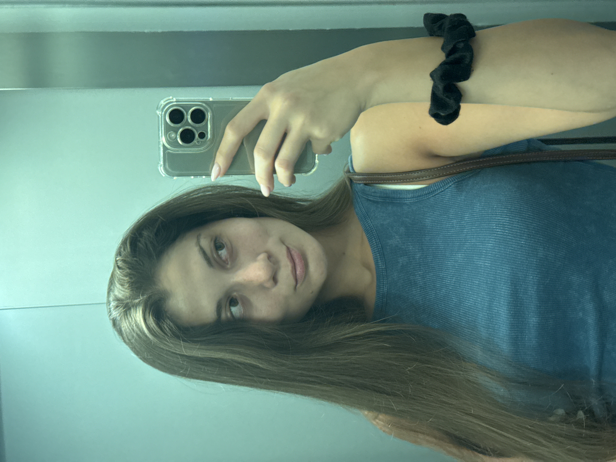 Mirror selfie in a Burgas elevator, blue top and denim.