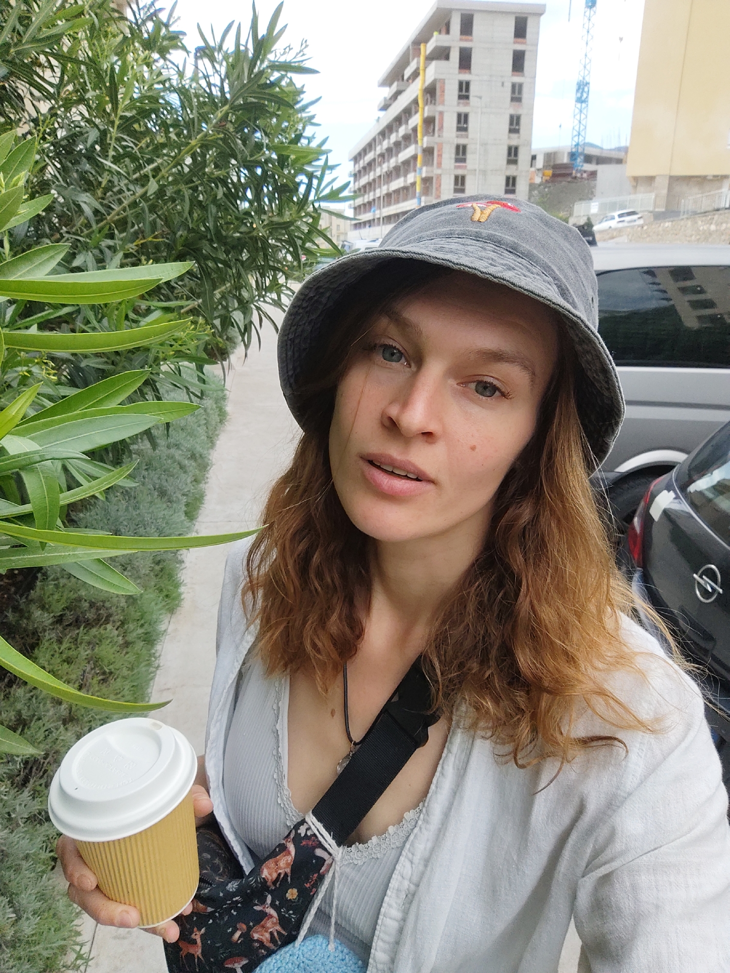 Woman with coffee observed on Boreti sidewalk
