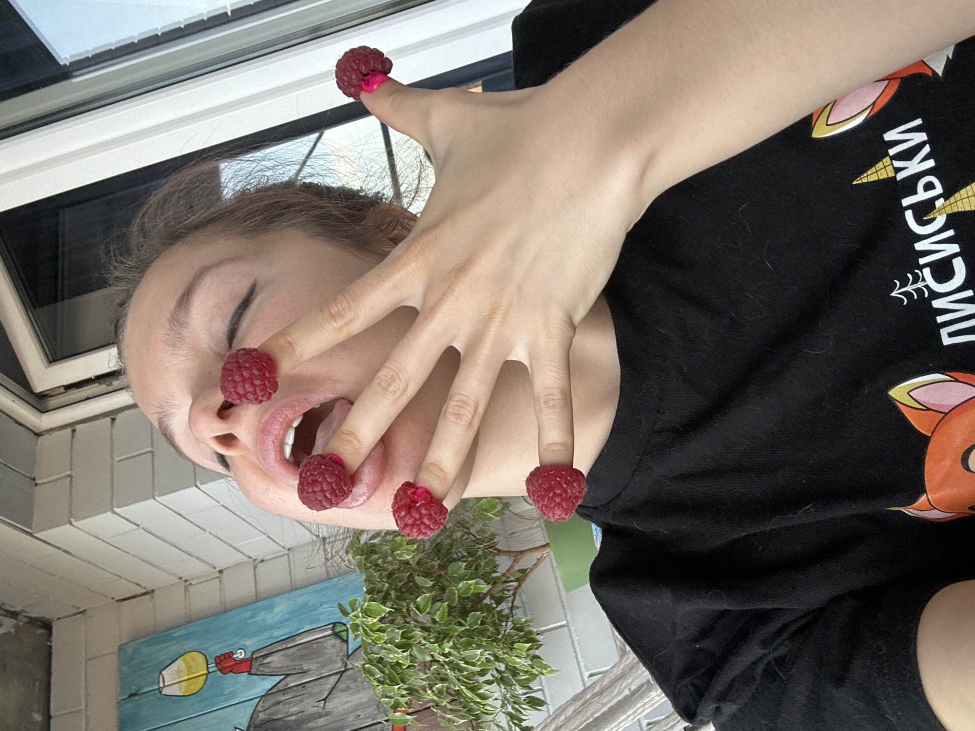 Person plays with raspberries on fingers in Vladimir
