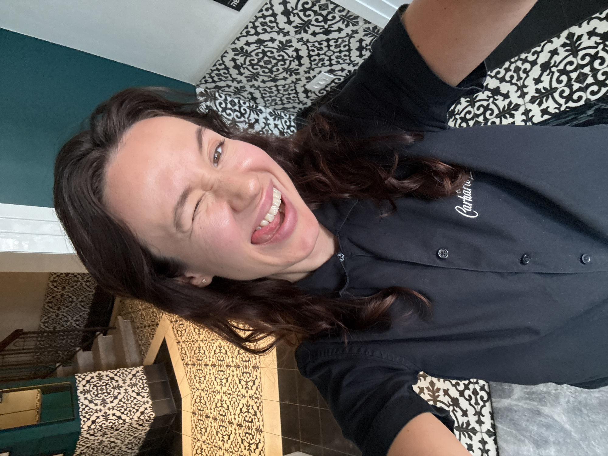 Back-to-back indoor selfies in Tel Aviv, branded work shirts