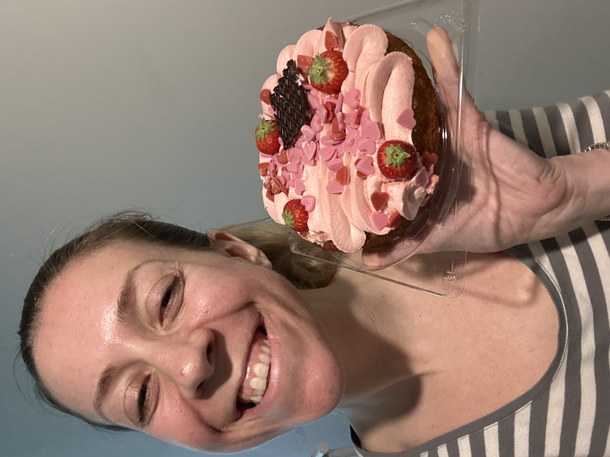Woman displays strawberry cake, tends garden in Amsterdam afternoon