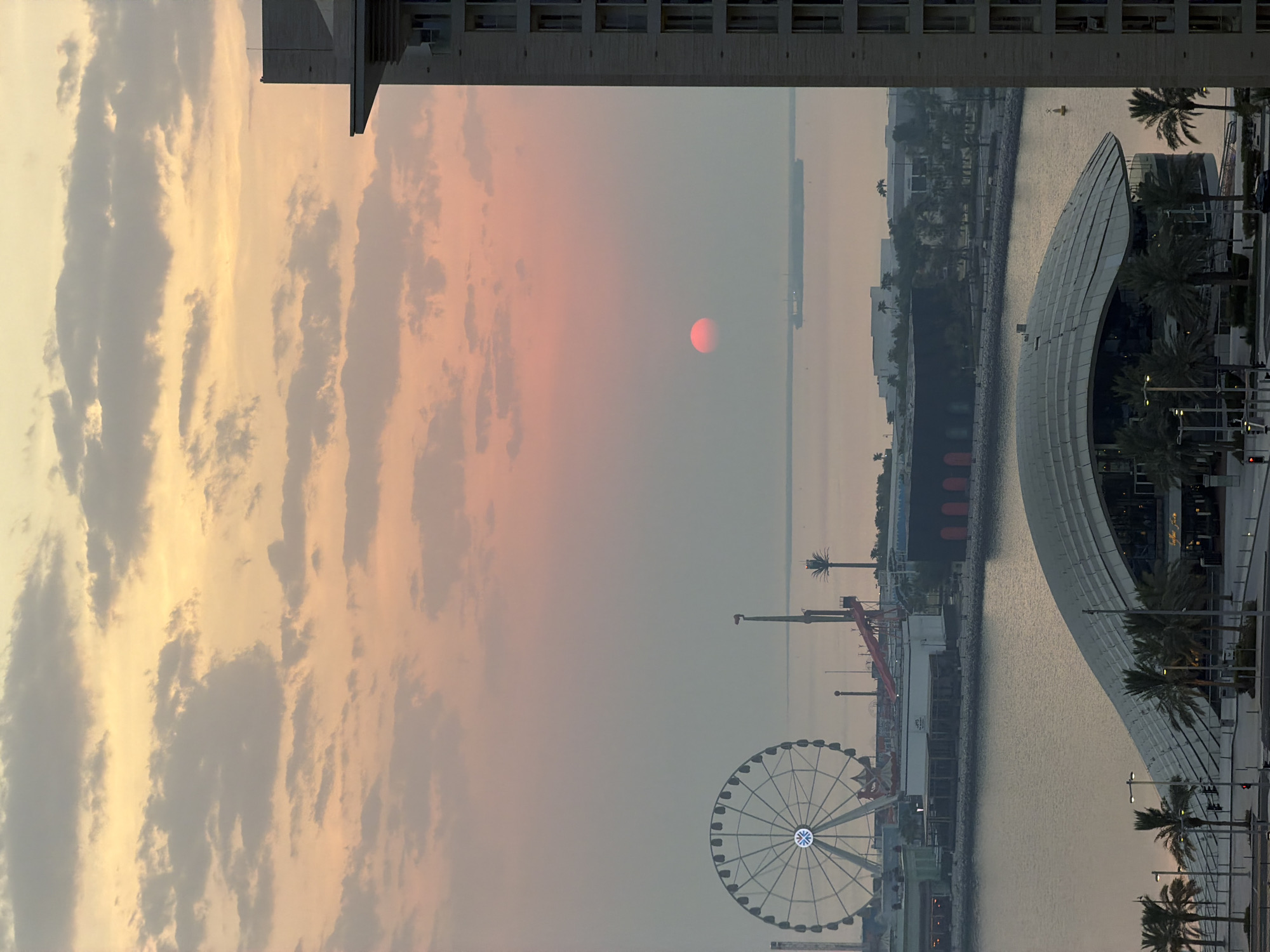 Lusail waterfront at sunrise, Ferris wheel and Gulf skyline.