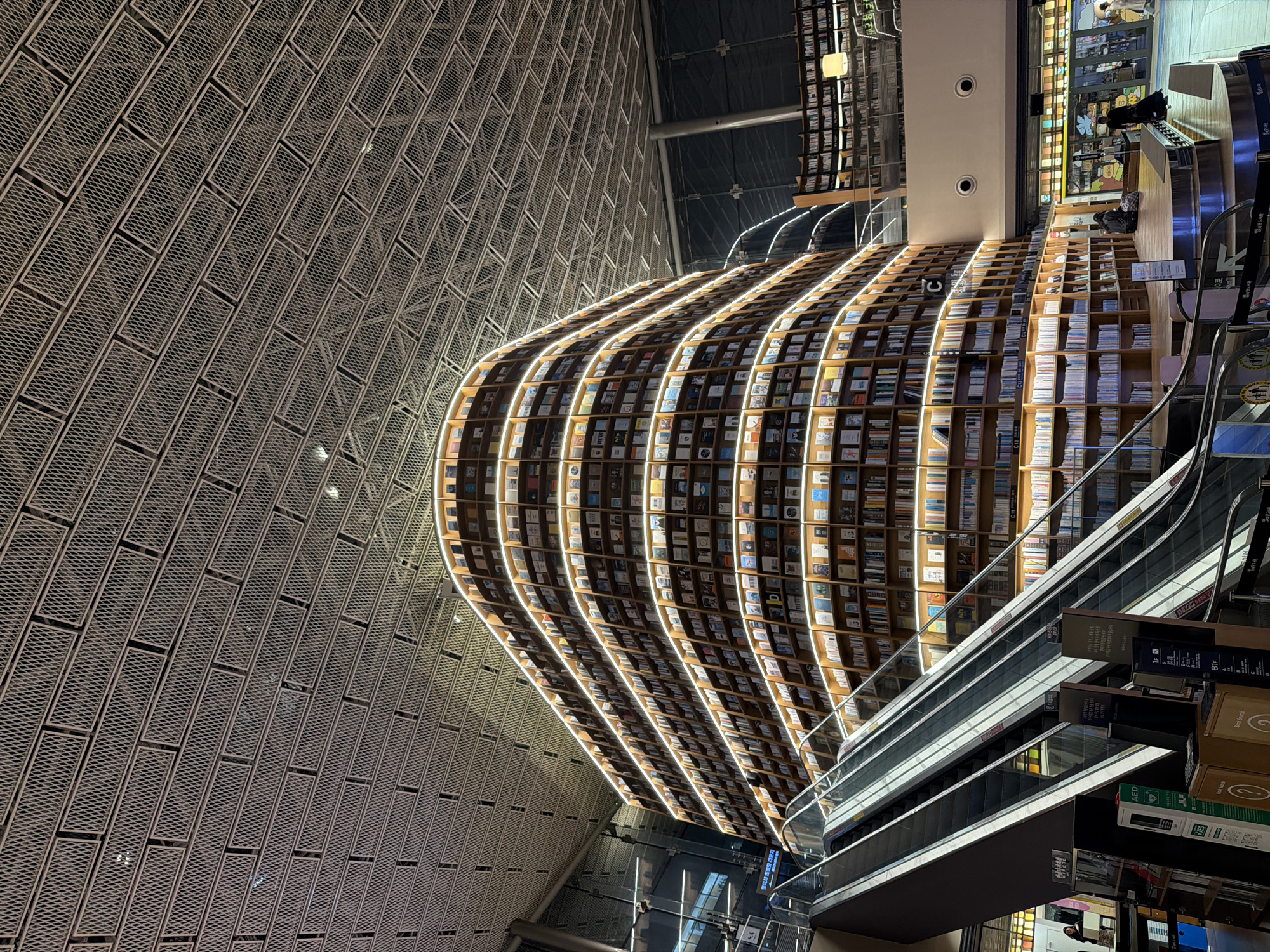Visitor photographs iconic curved bookshelves at Seoul's Starfield Library