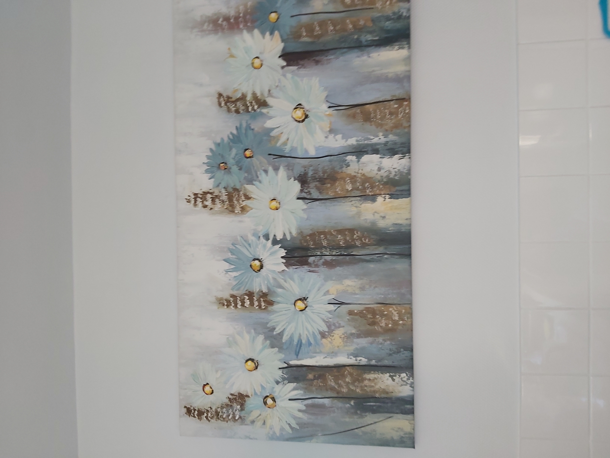 Quiet details of a home interior: art, remote, and flowers