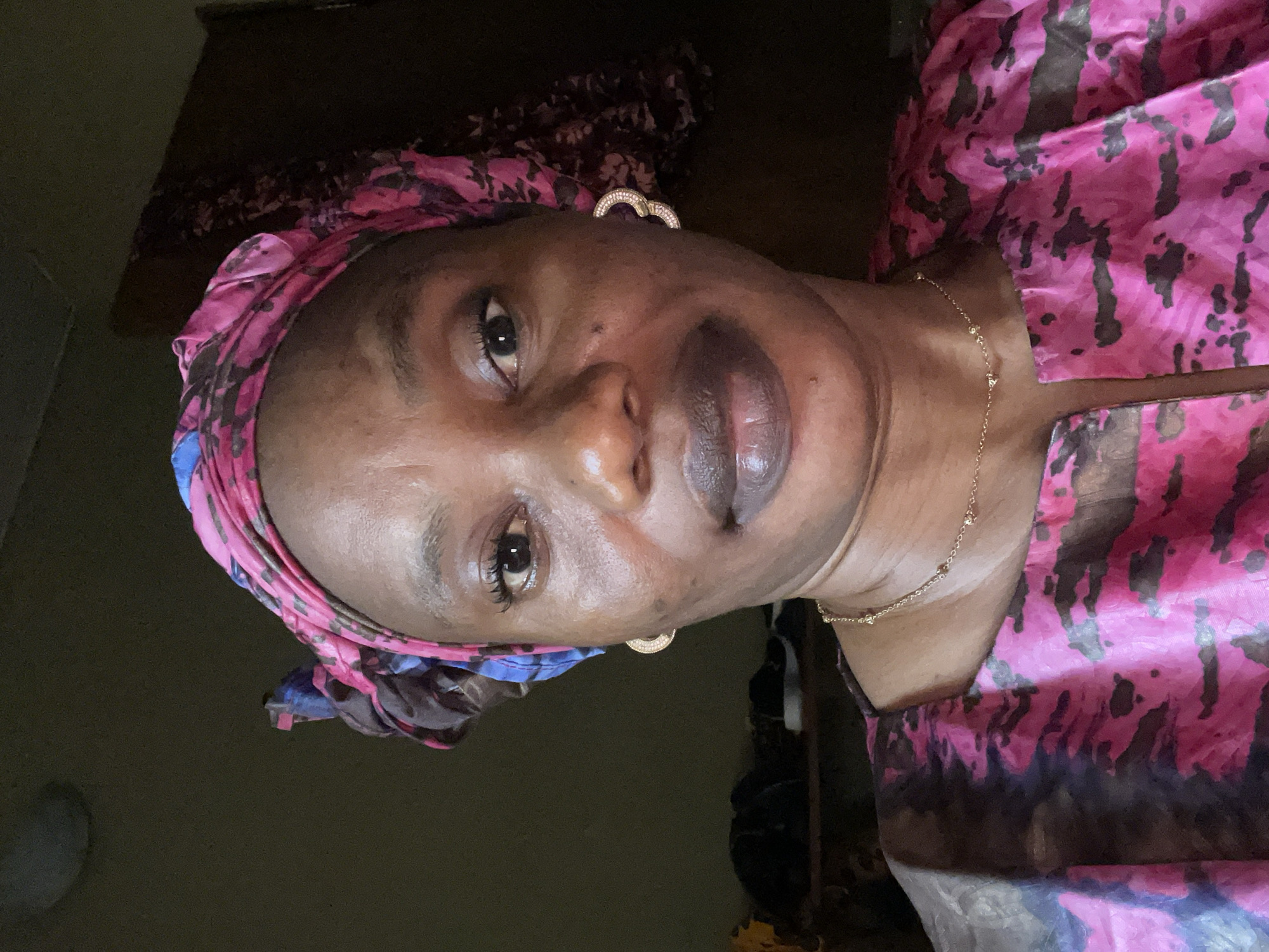Portrait captured of woman in patterned headwrap in Narayi