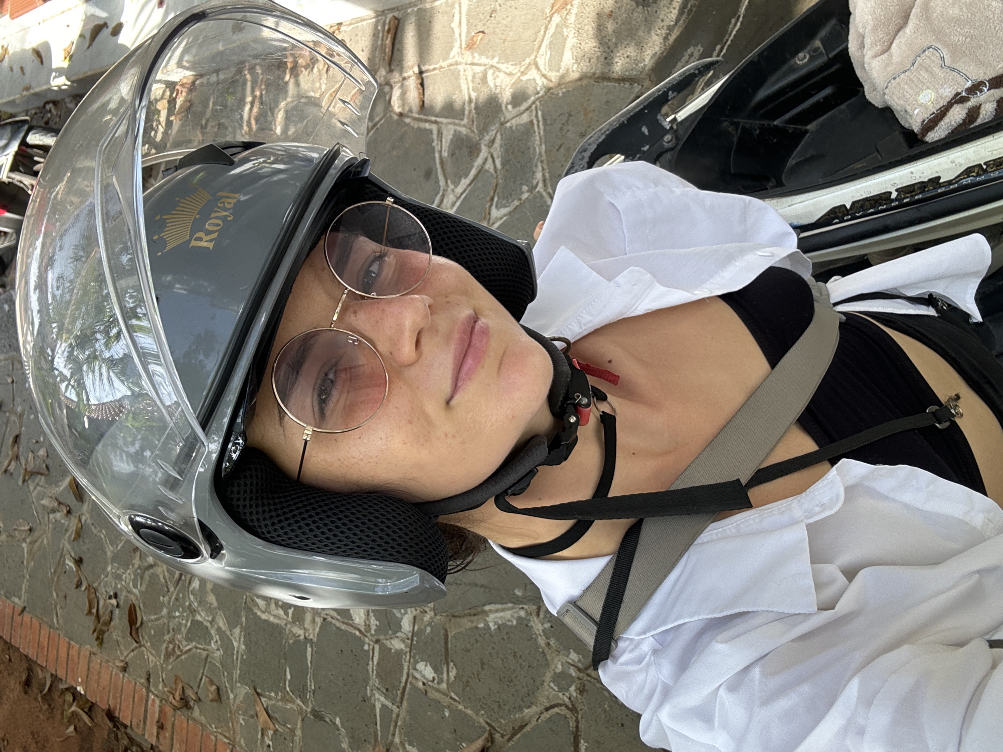 Woman in motorcycle helmet lies on brick surface in Vietnam