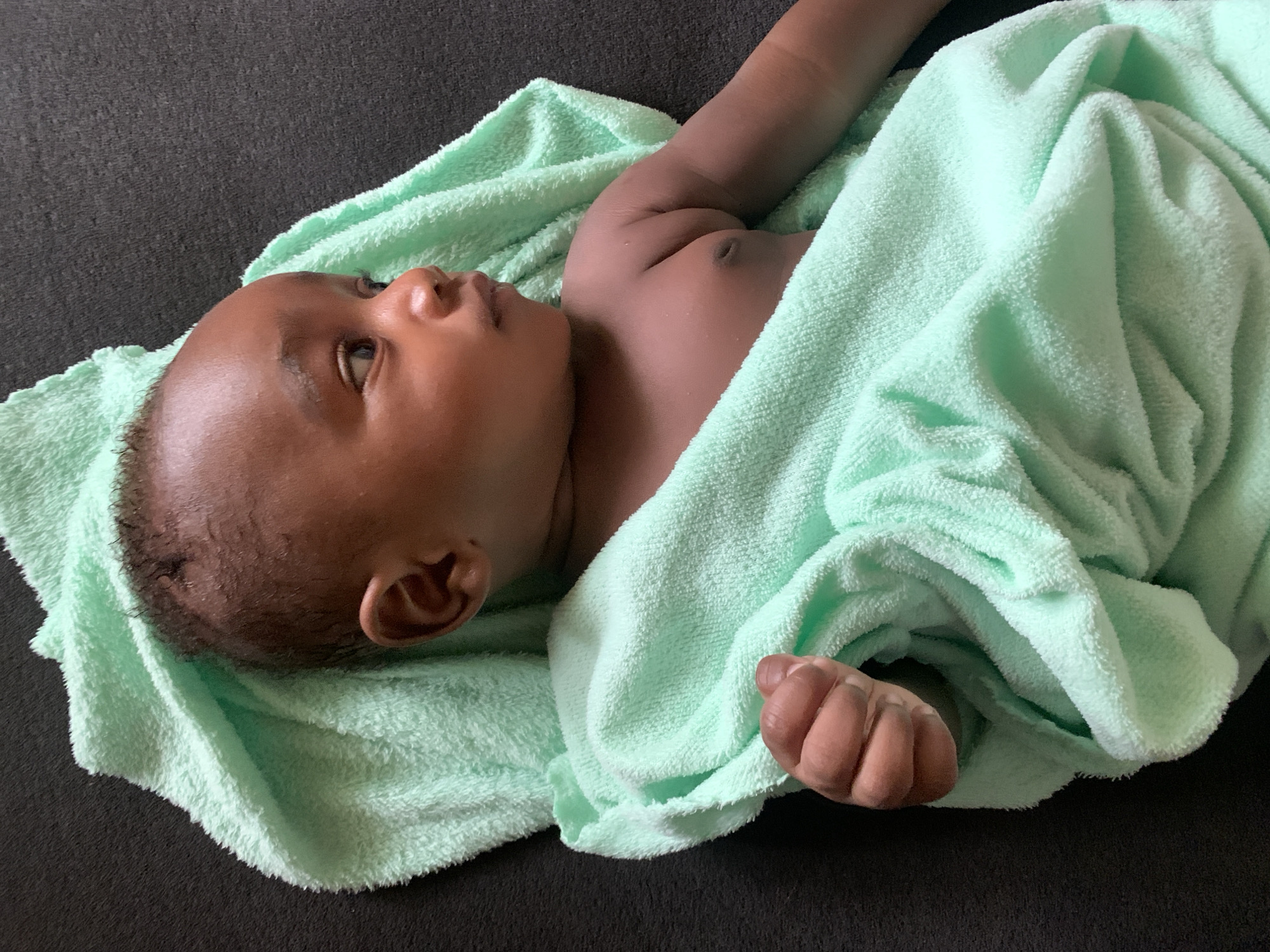 Baby photographed wrapped in green towel in Nigeria