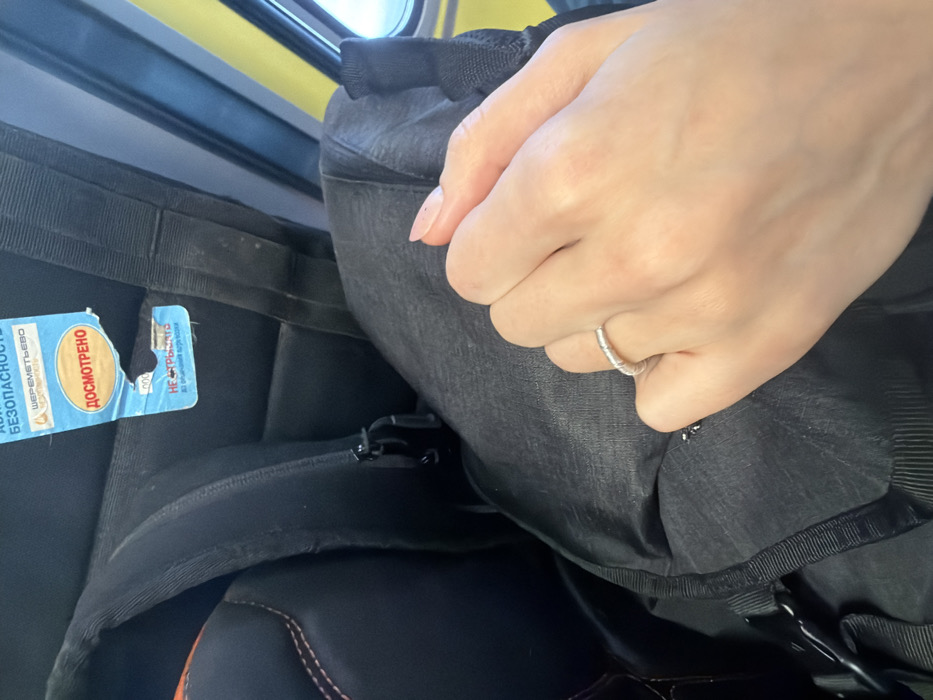 Traveler's hand on tagged backpack observed in Otaru